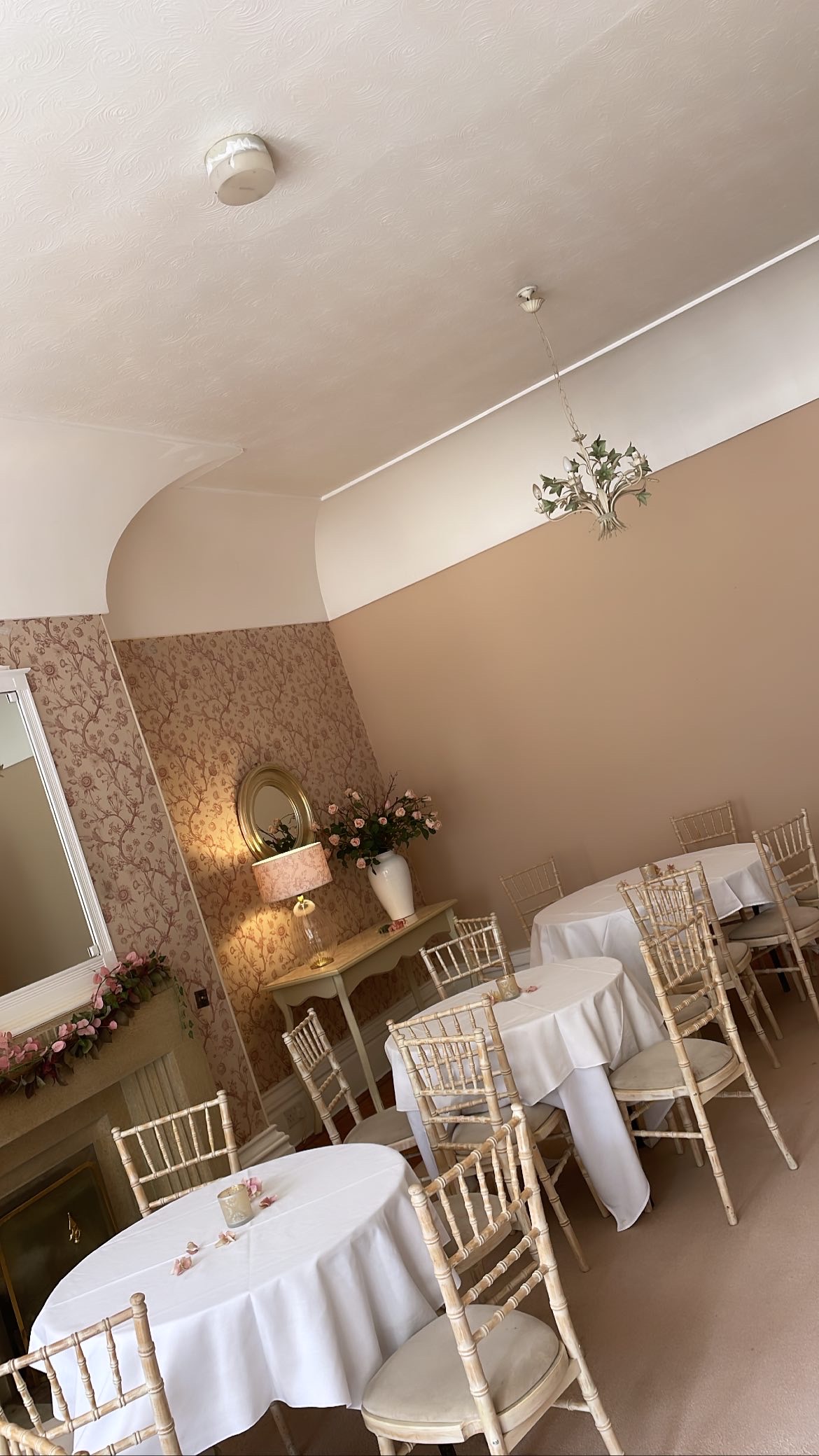 Elegant meeting space at Berrow Court with floral wallpaper and chiavari chairs.