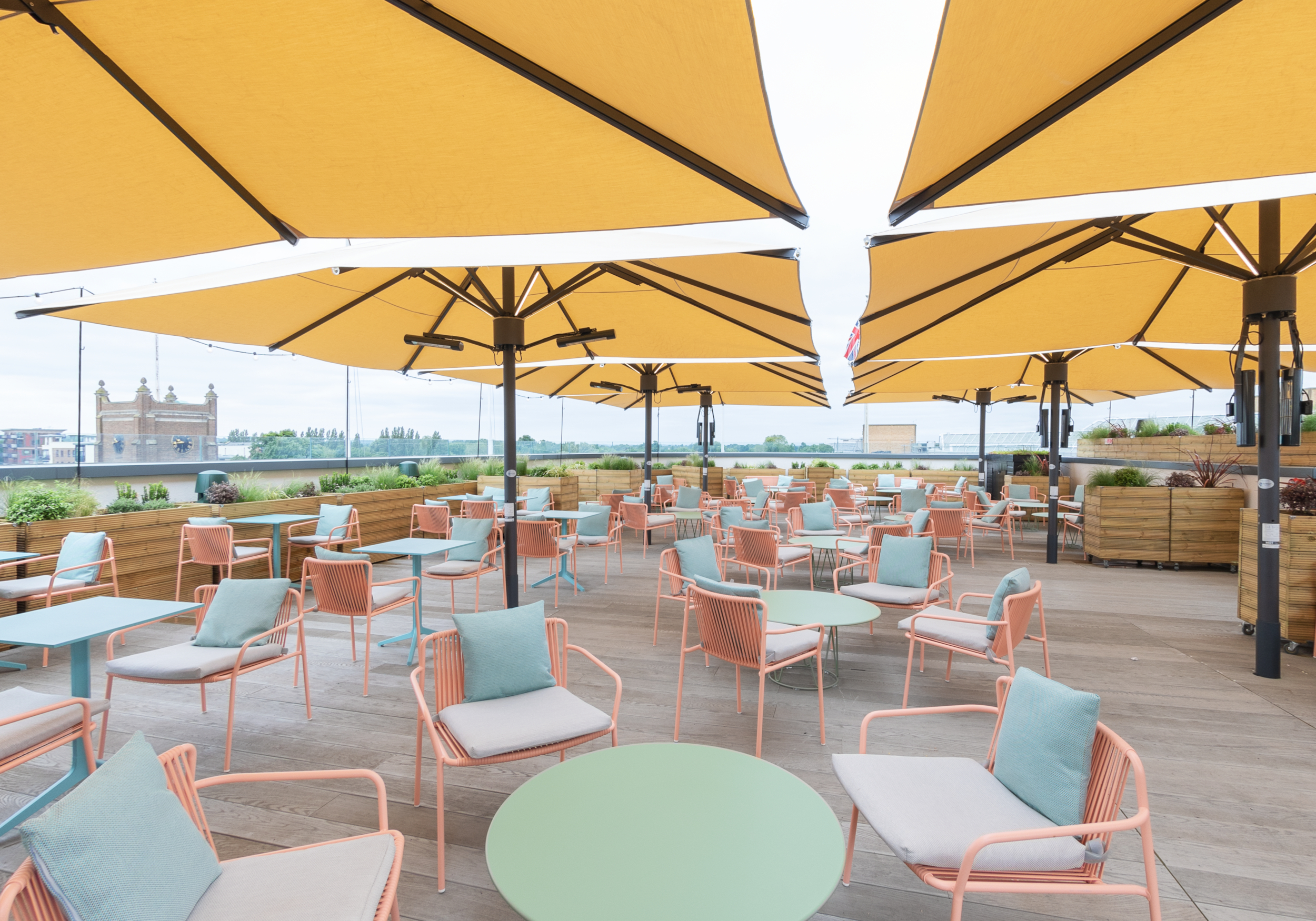 Curzon Kingston outdoor event space with colorful seating and yellow umbrellas for gatherings.