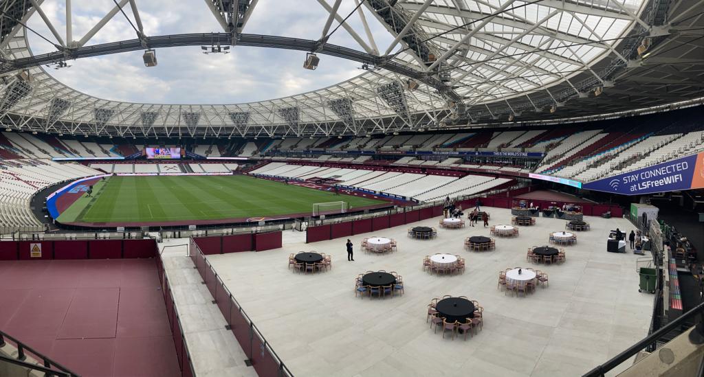 Versatile event space at London Stadium with round tables for corporate gatherings.