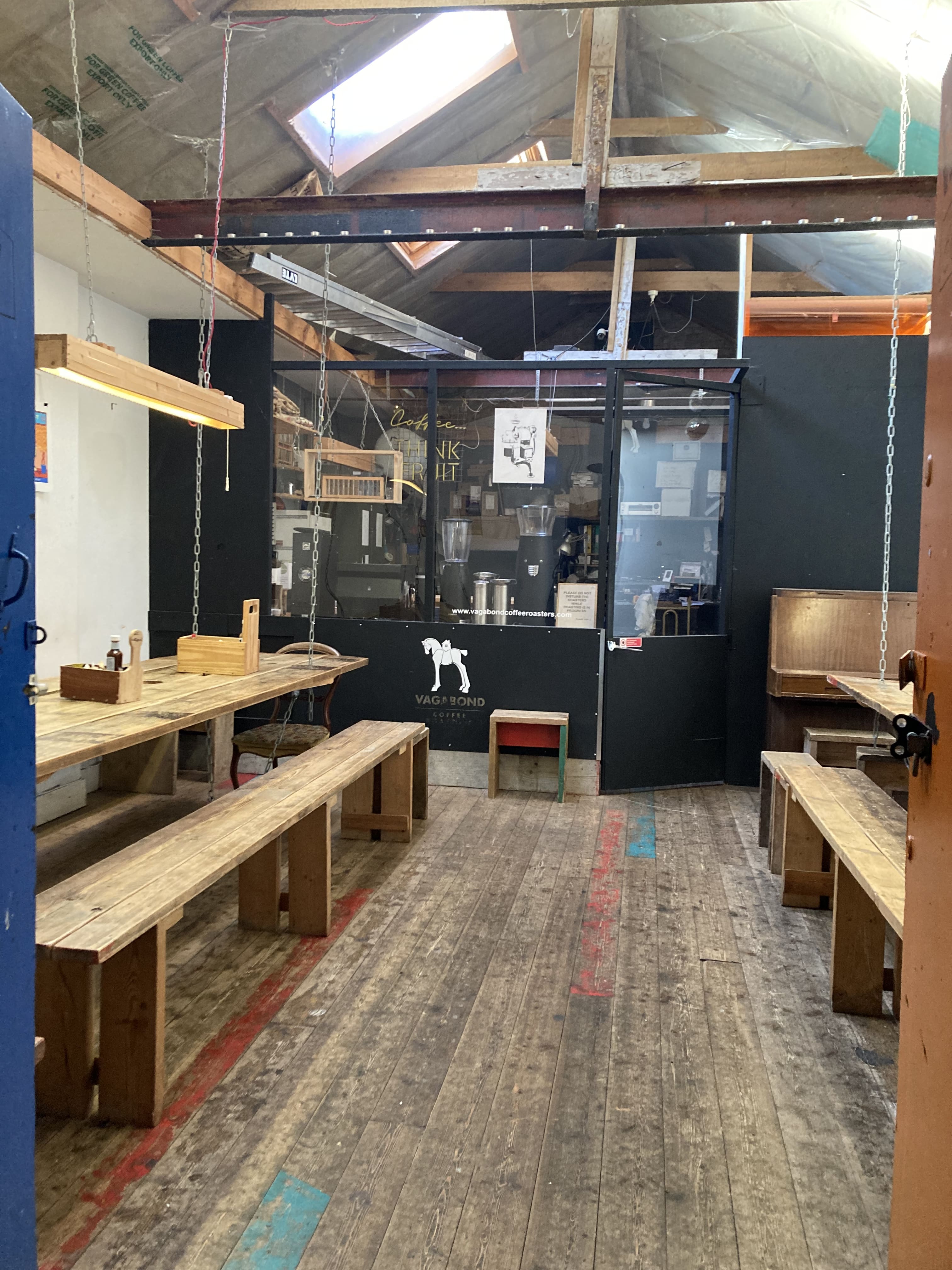 Versatile meeting space at Vagabond Coffee with rustic tables for workshops and gatherings.