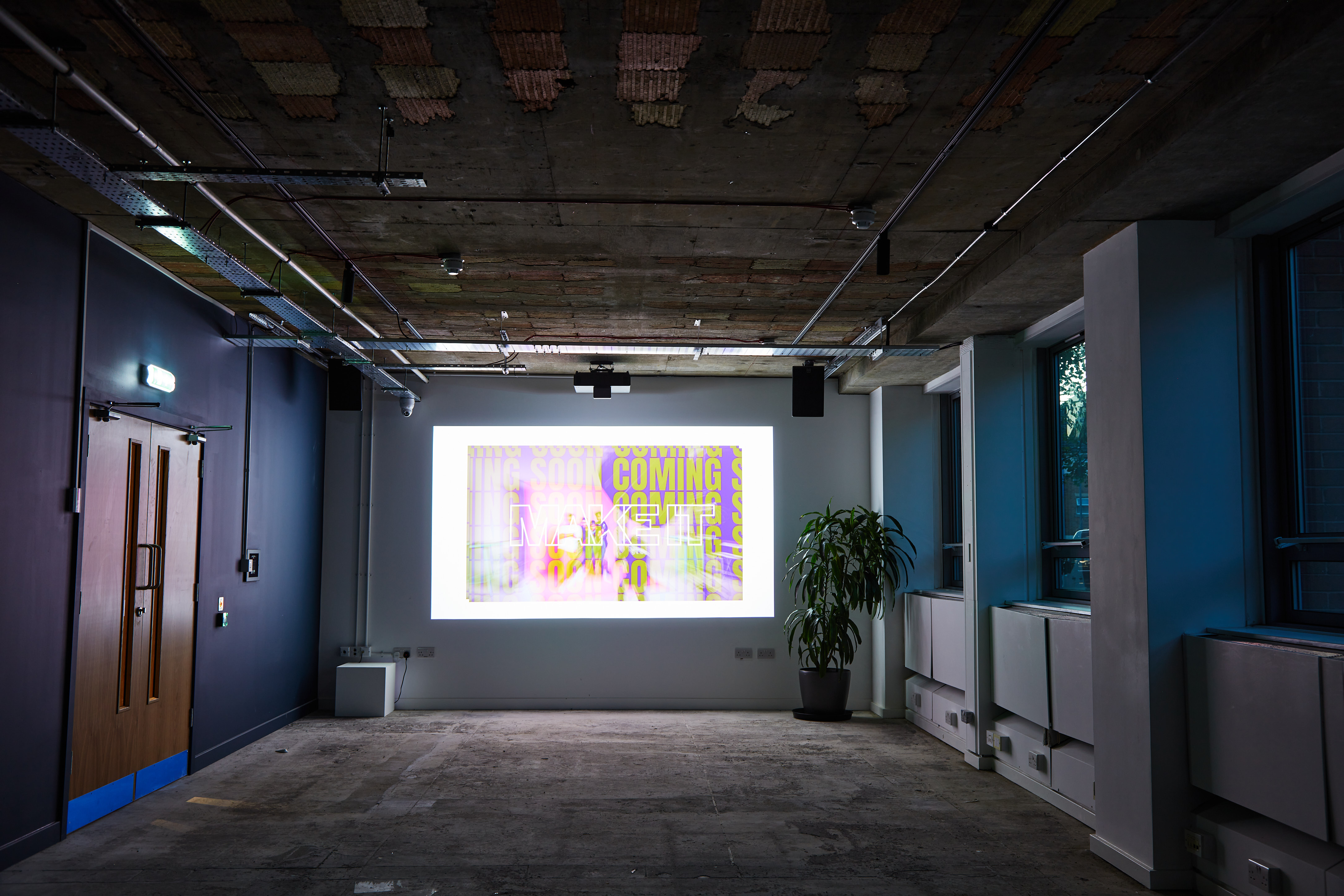 Versatile FACTORY 15 event space with large projection screen for corporate meetings and workshops.