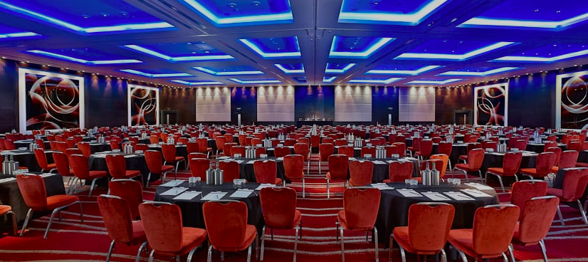 Westminster Ballroom setup for a conference with elegant lighting and red chairs.