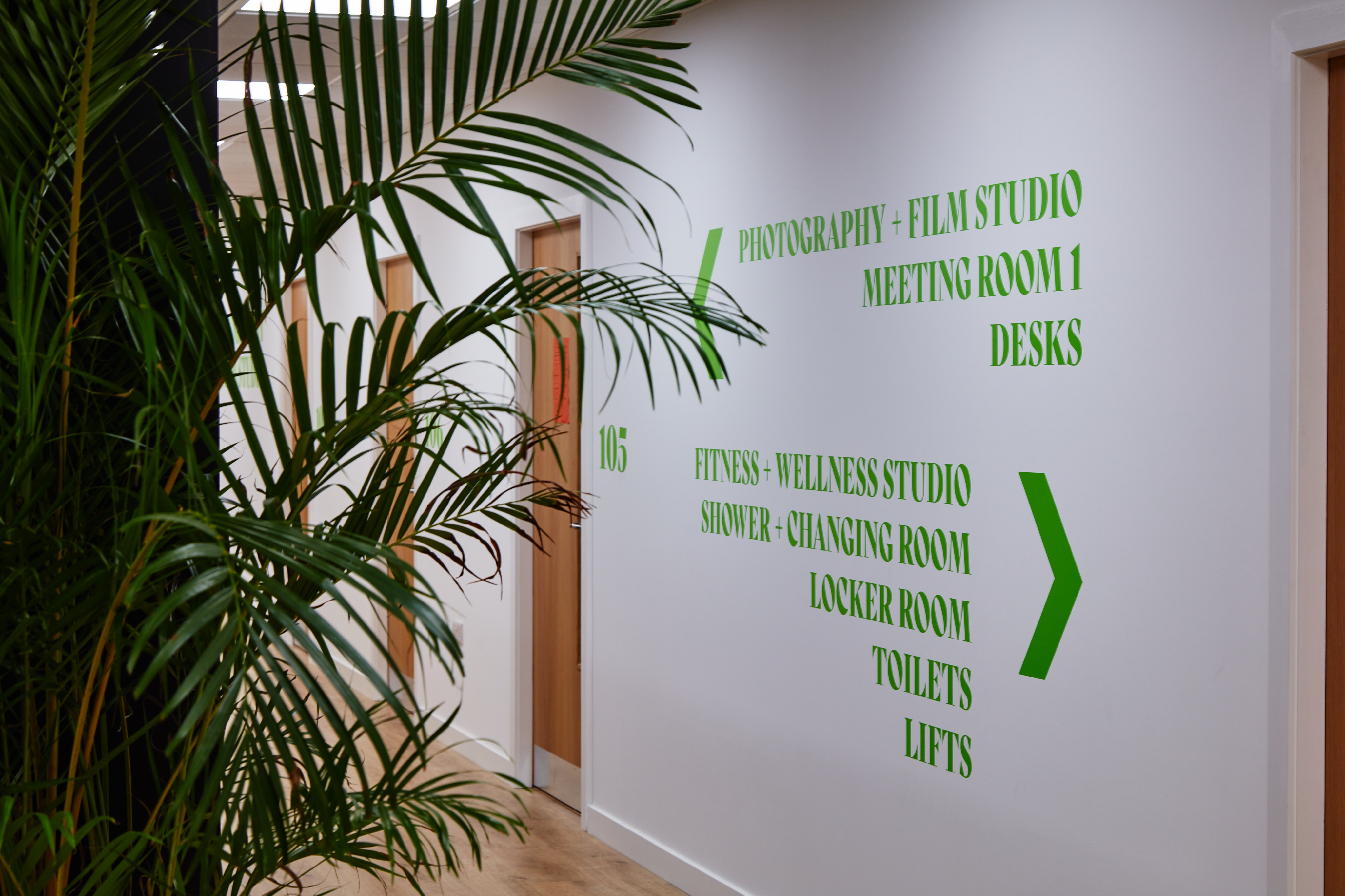 Wellness and Fitness Studio corridor with green signage for events in Barking.