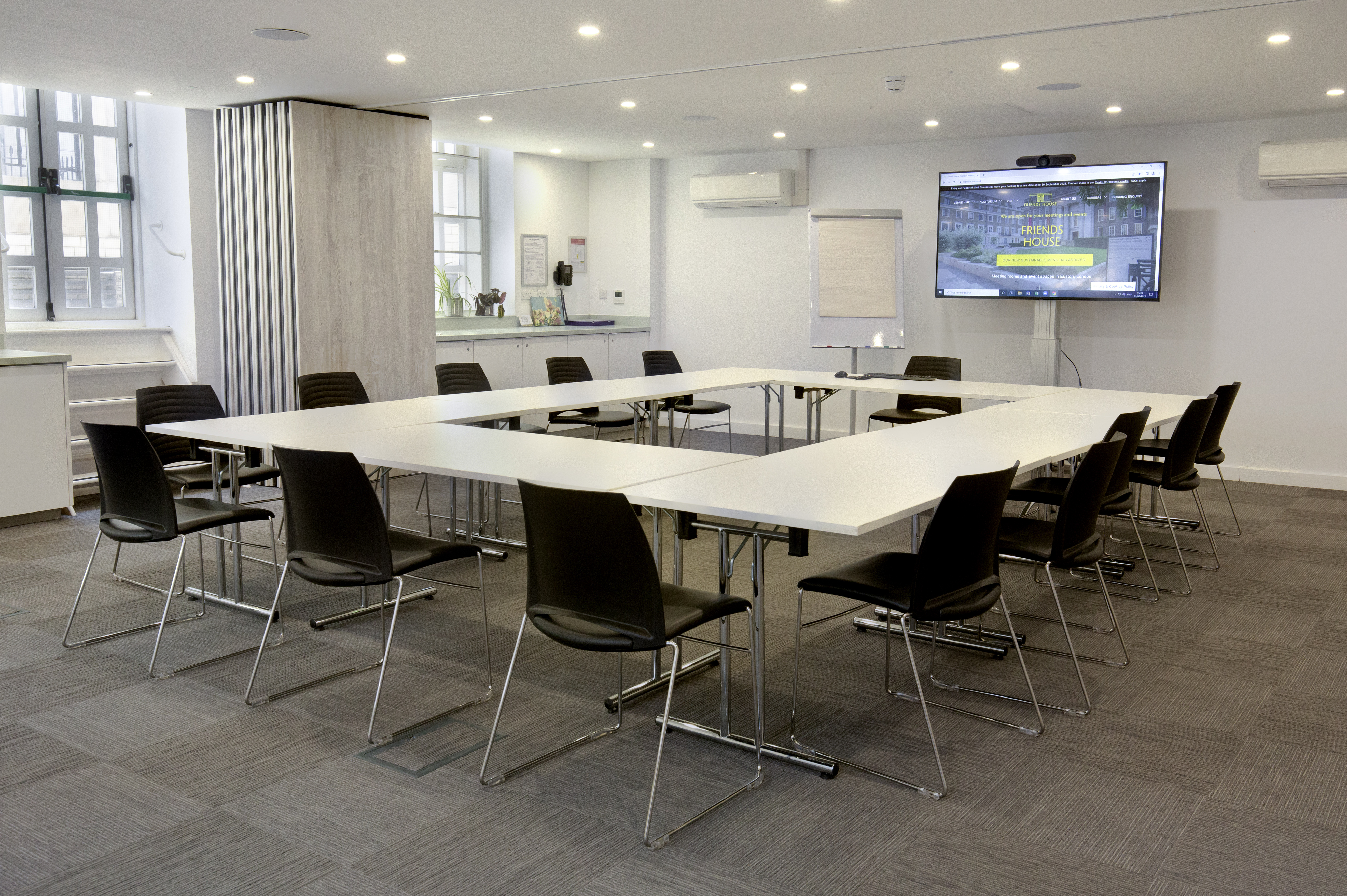 Modern meeting room with U-shaped table for collaboration at Friends House.