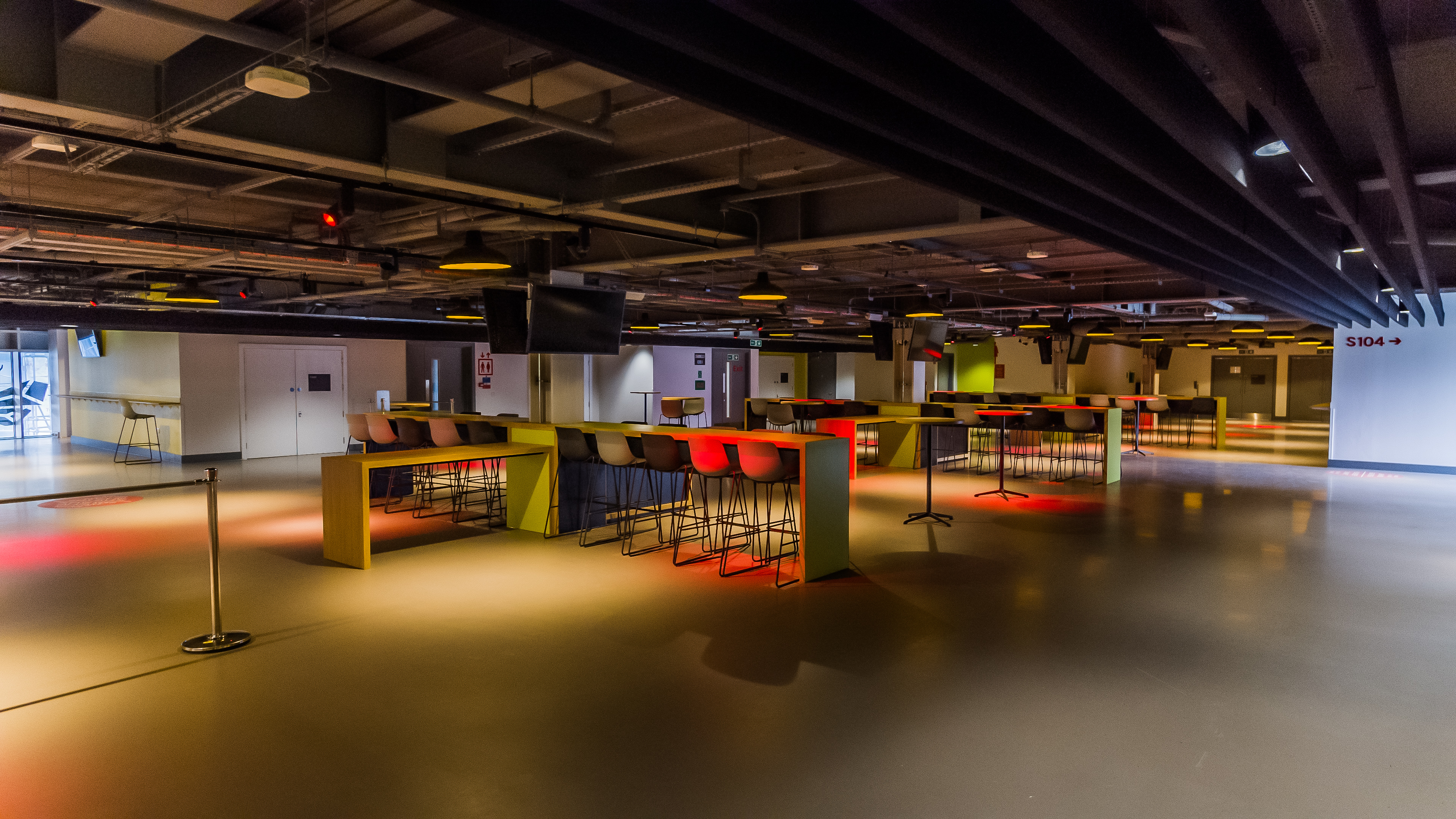 Modern event space at Brentford FC with high tables for networking and receptions.