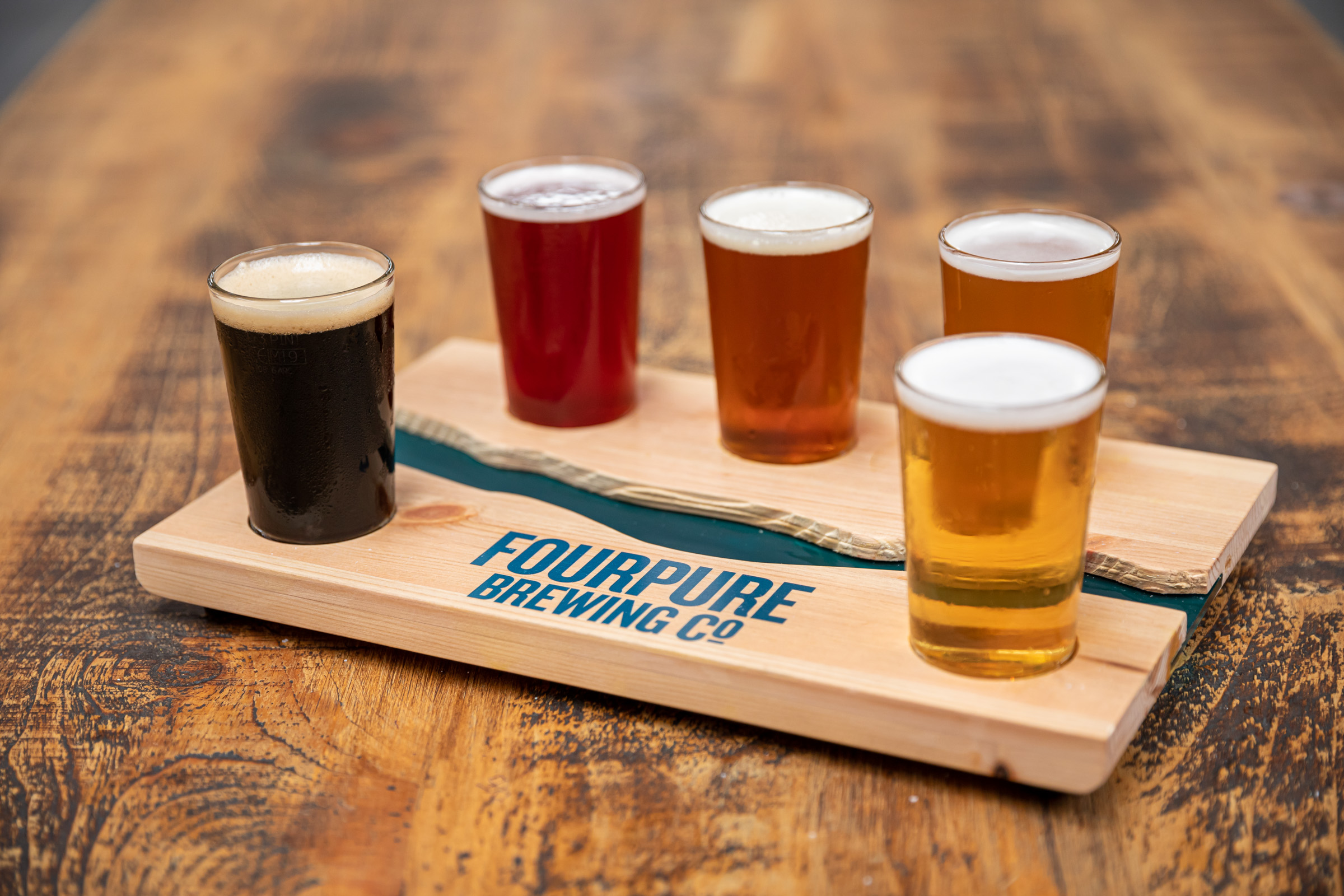 Craft beer flight on wooden paddle at Treehouse Tasting Room, ideal for networking events.