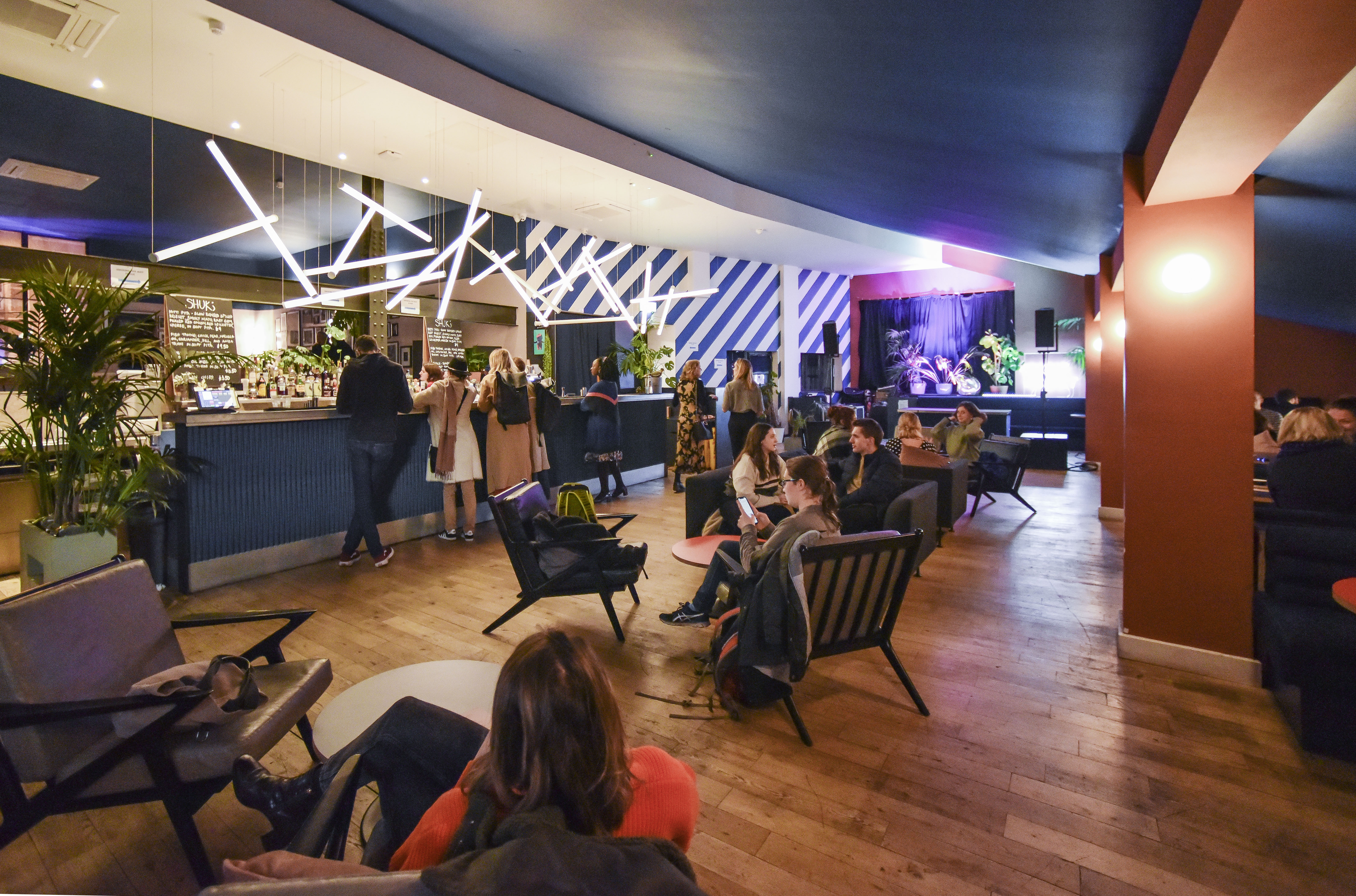 Vibrant Bar + Kitchen event space with modern seating for networking and gatherings.