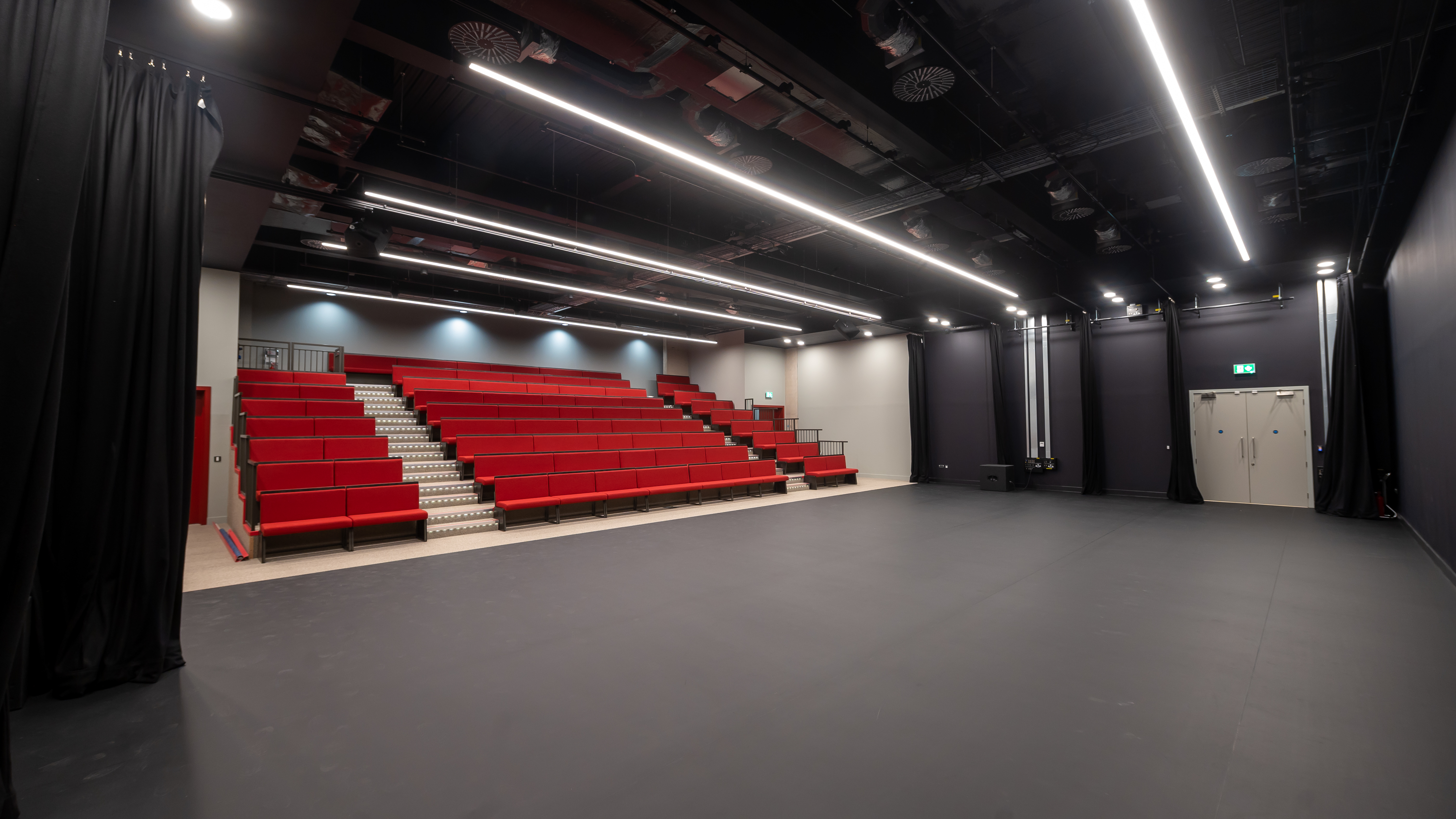 Aud Jebsen Studio Theatre with tiered red seating for performances and workshops.