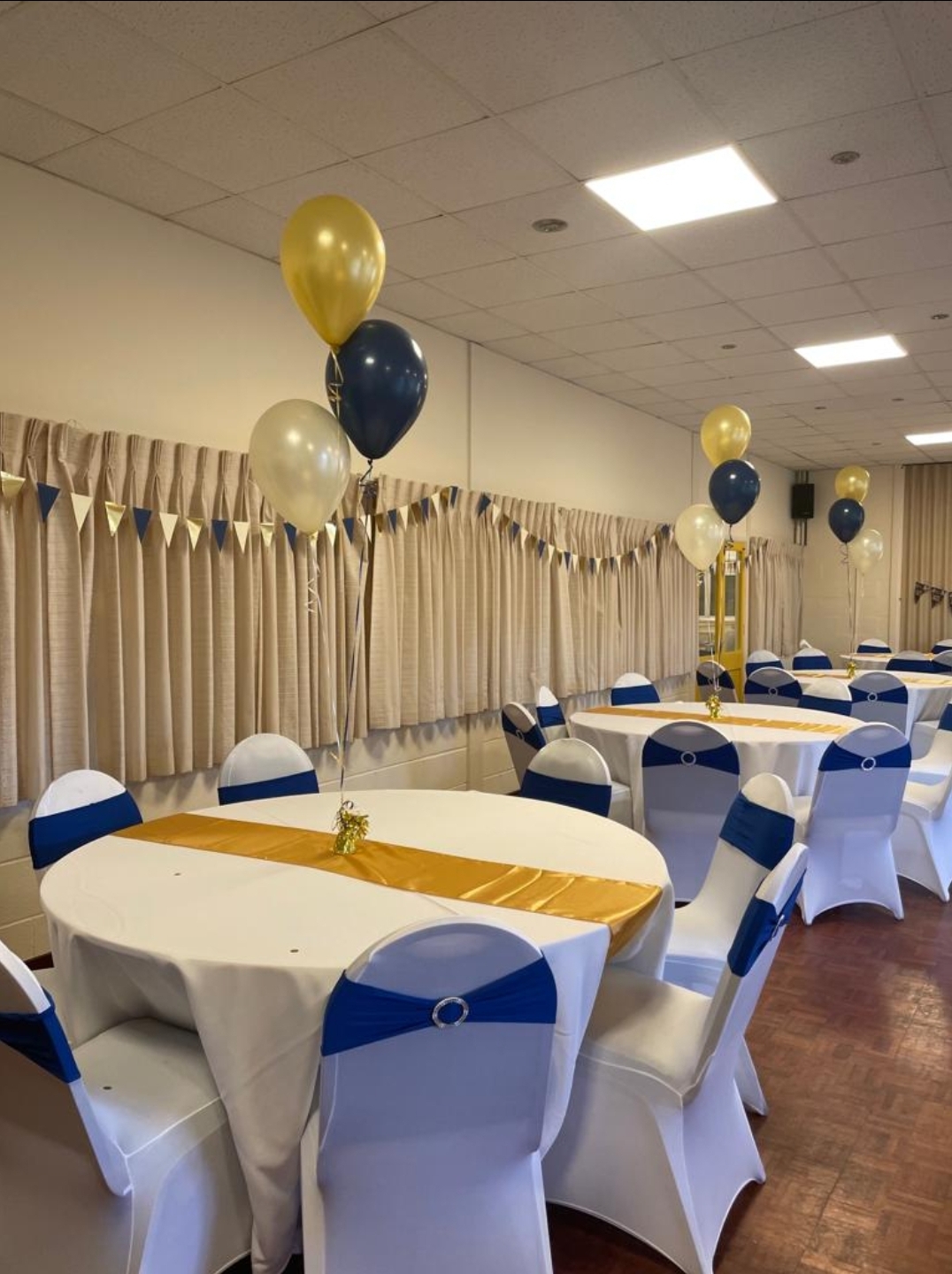 Event space in Glebelands with round tables, white linens, and festive decor for gatherings.