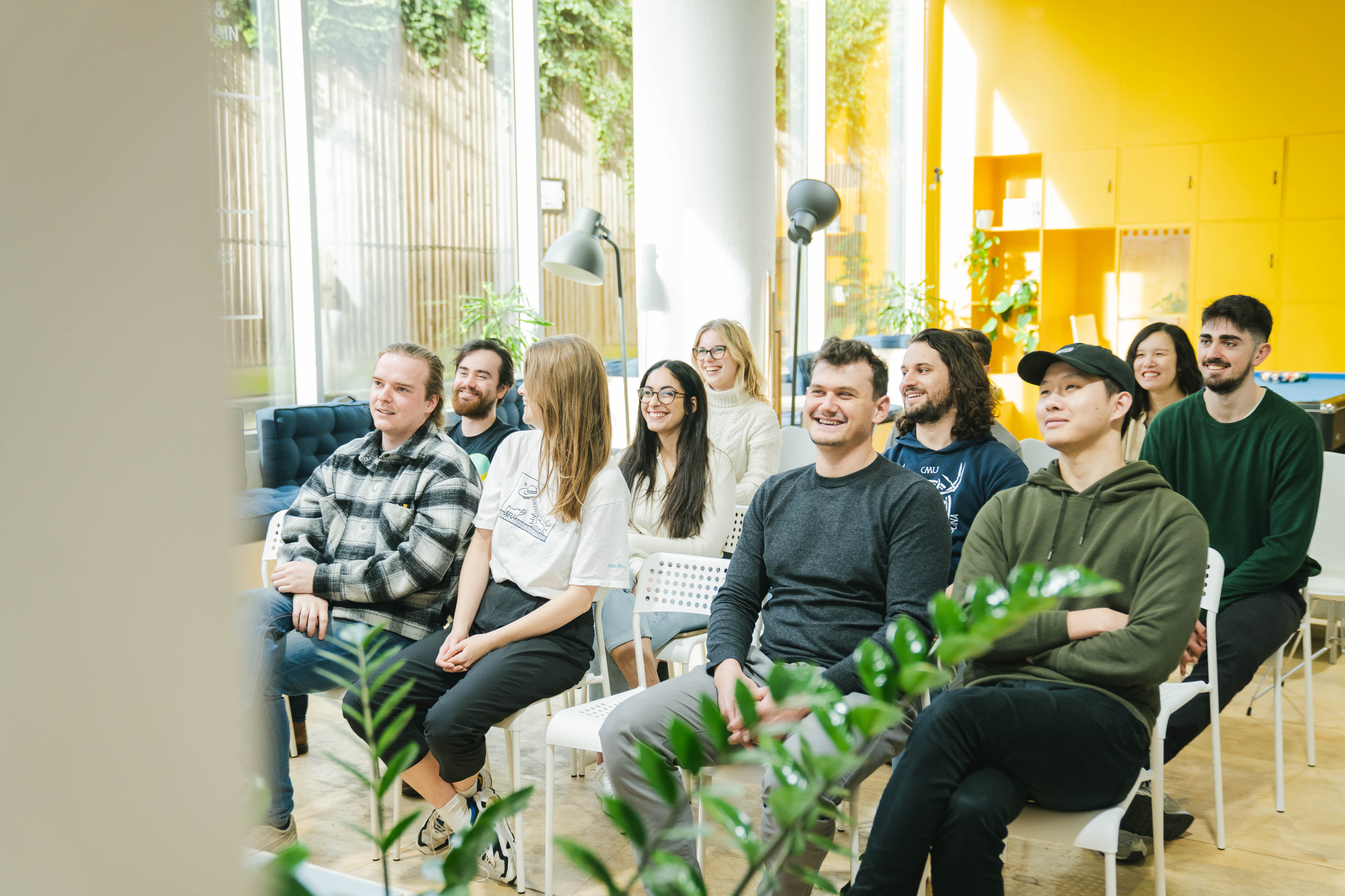 Diverse attendees in a bright event space fostering collaboration and creativity.