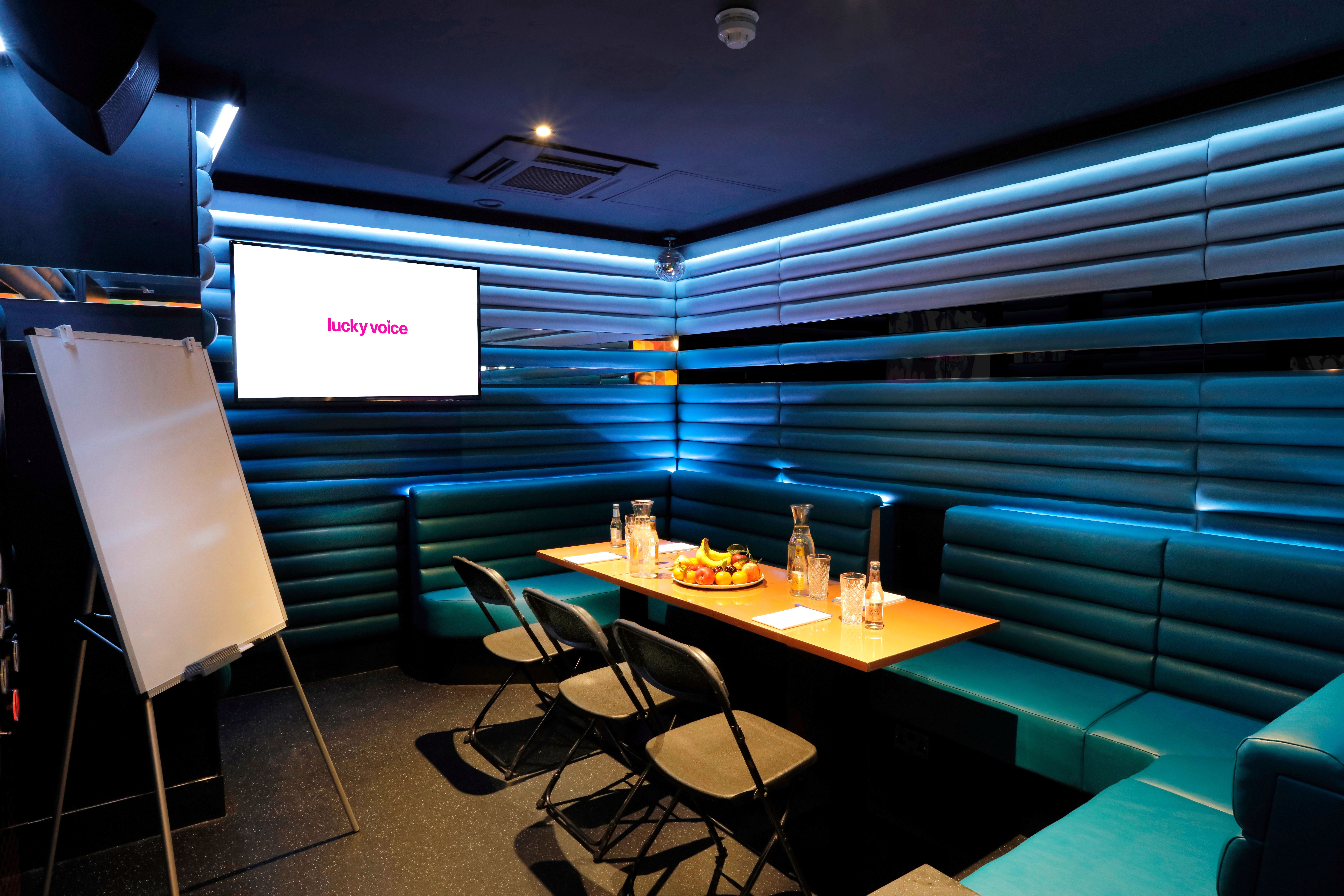 Intimate meeting space at Lucky Voice Holborn with sleek seating for team brainstorming sessions.