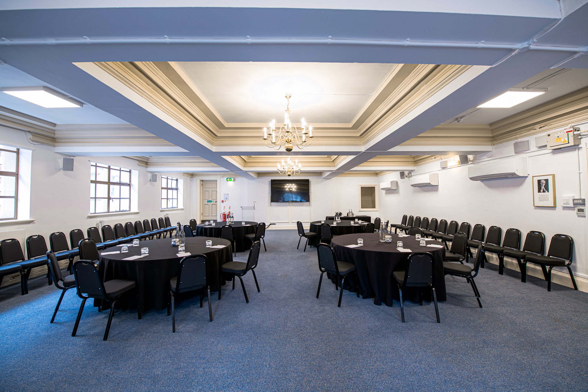 William Sangster in a sophisticated meeting room with circular tables for corporate events.