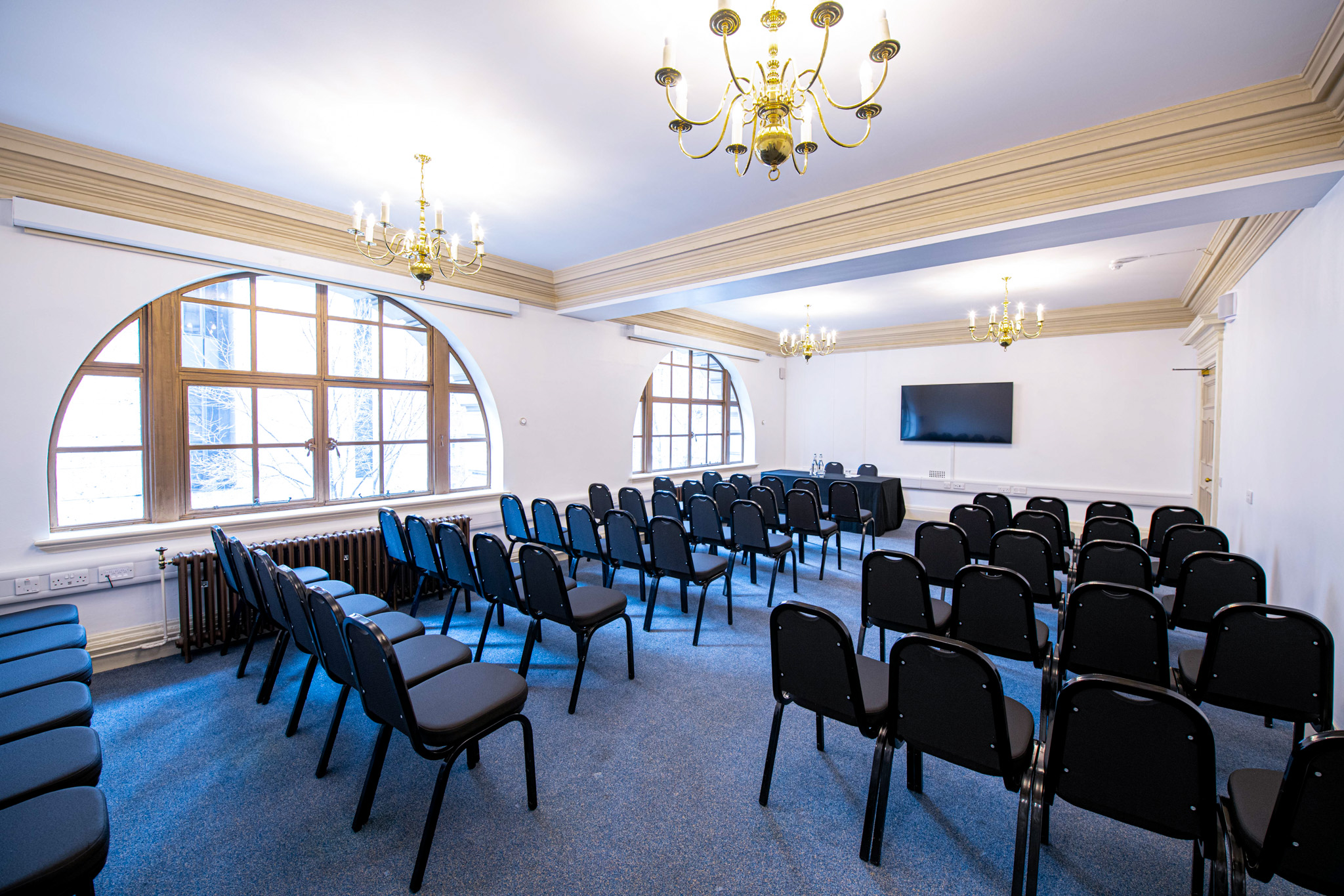 John Tudor in Central Hall Westminster, a versatile meeting room with black chairs.