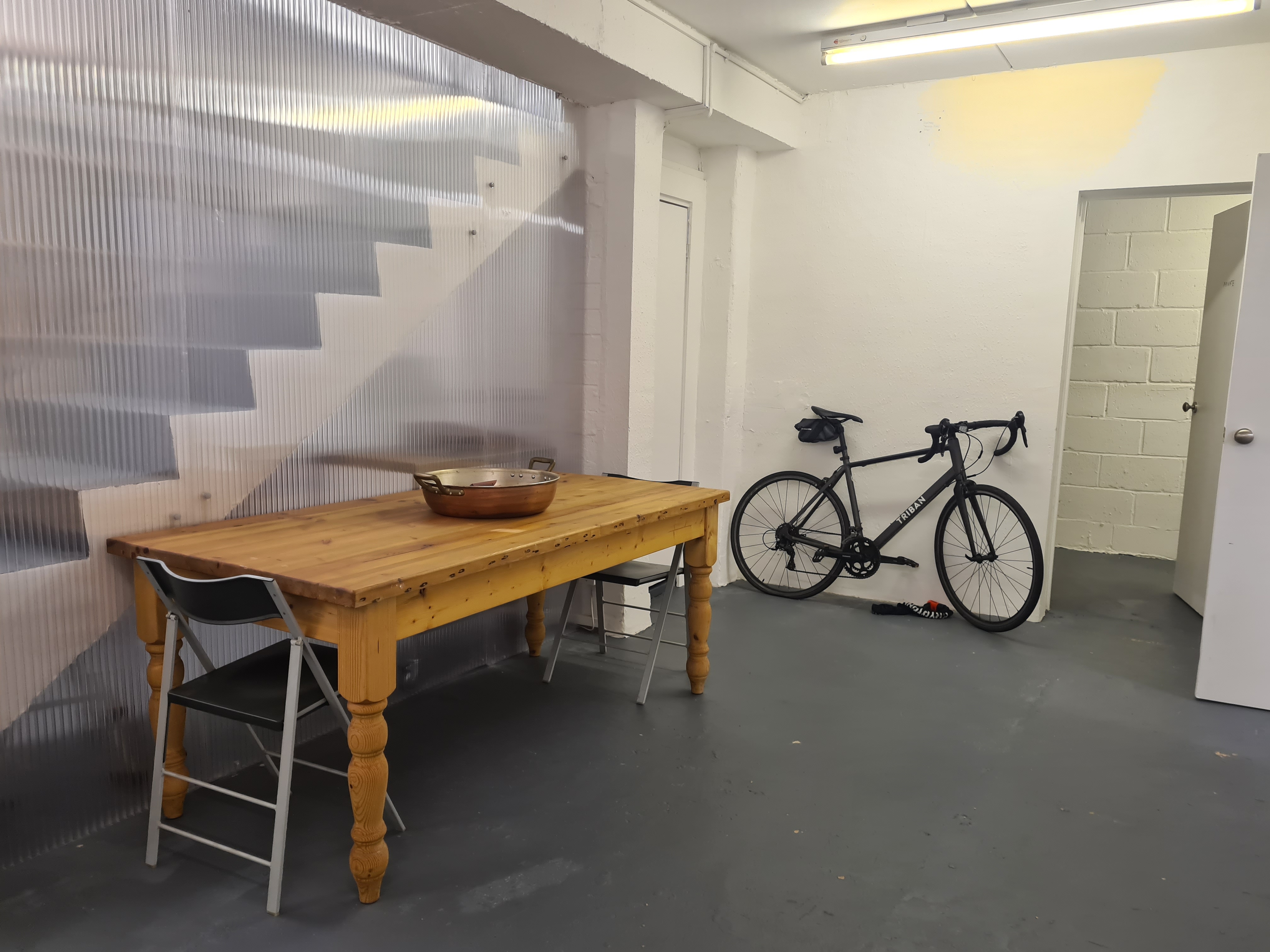 Minimalist workshop room with wooden table, ideal for creative meetings and brainstorming.