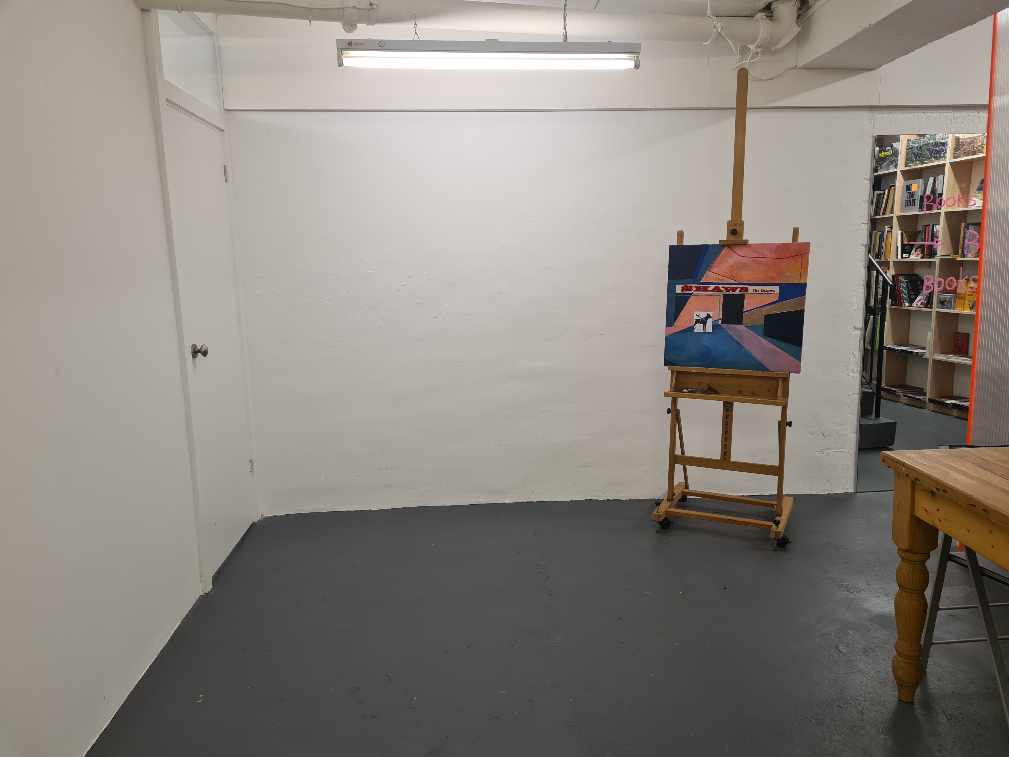 Minimalist workshop room with easel, ideal for creative events and gatherings.