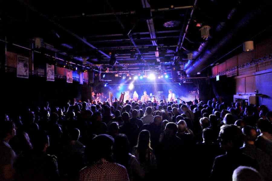 Vibrant live event at Newhampton Arts Centre with engaged audience and bright stage lighting.