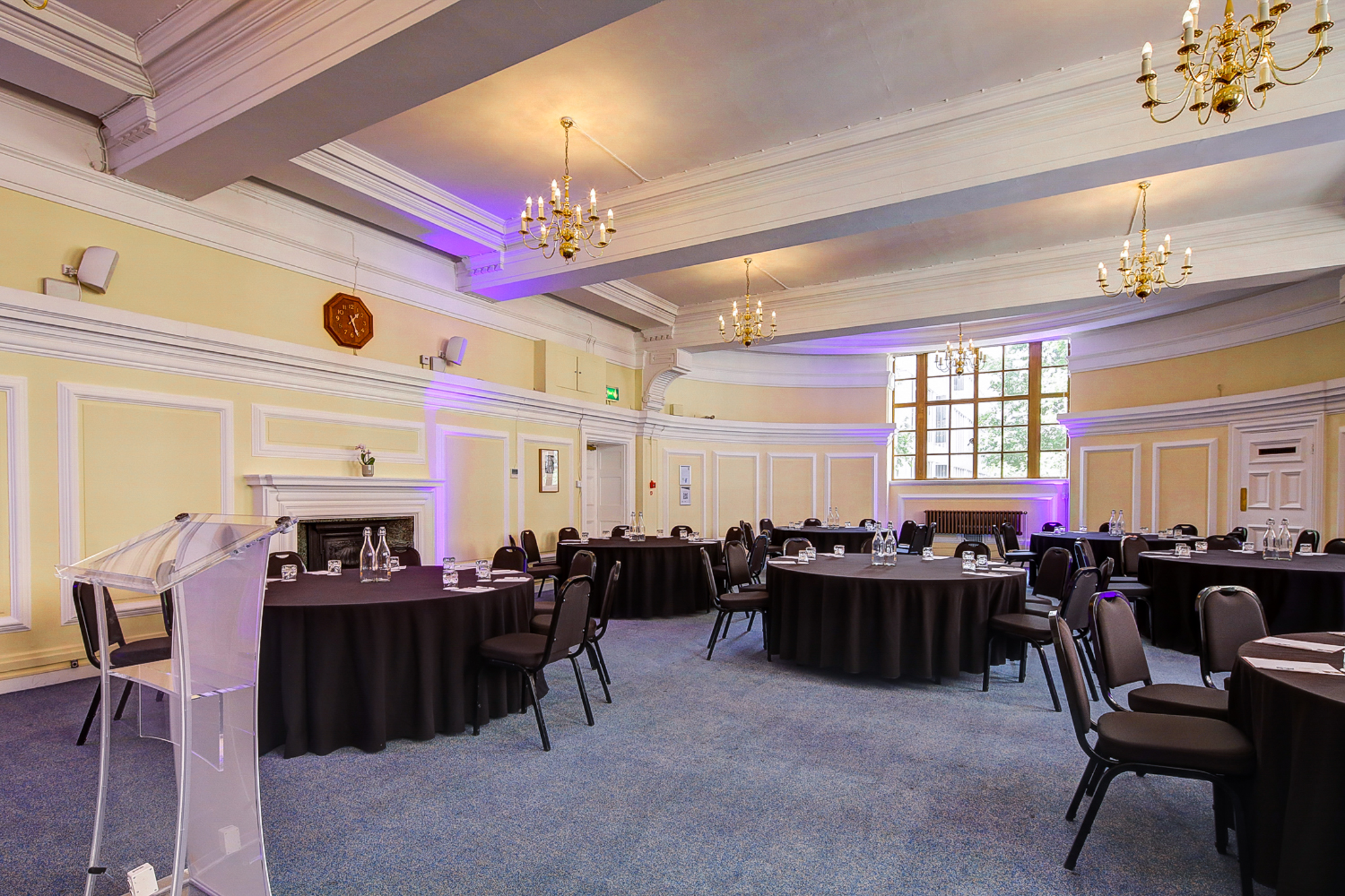 George Thomas at Central Hall Westminster, elegant meeting space with round tables and purple lighting.