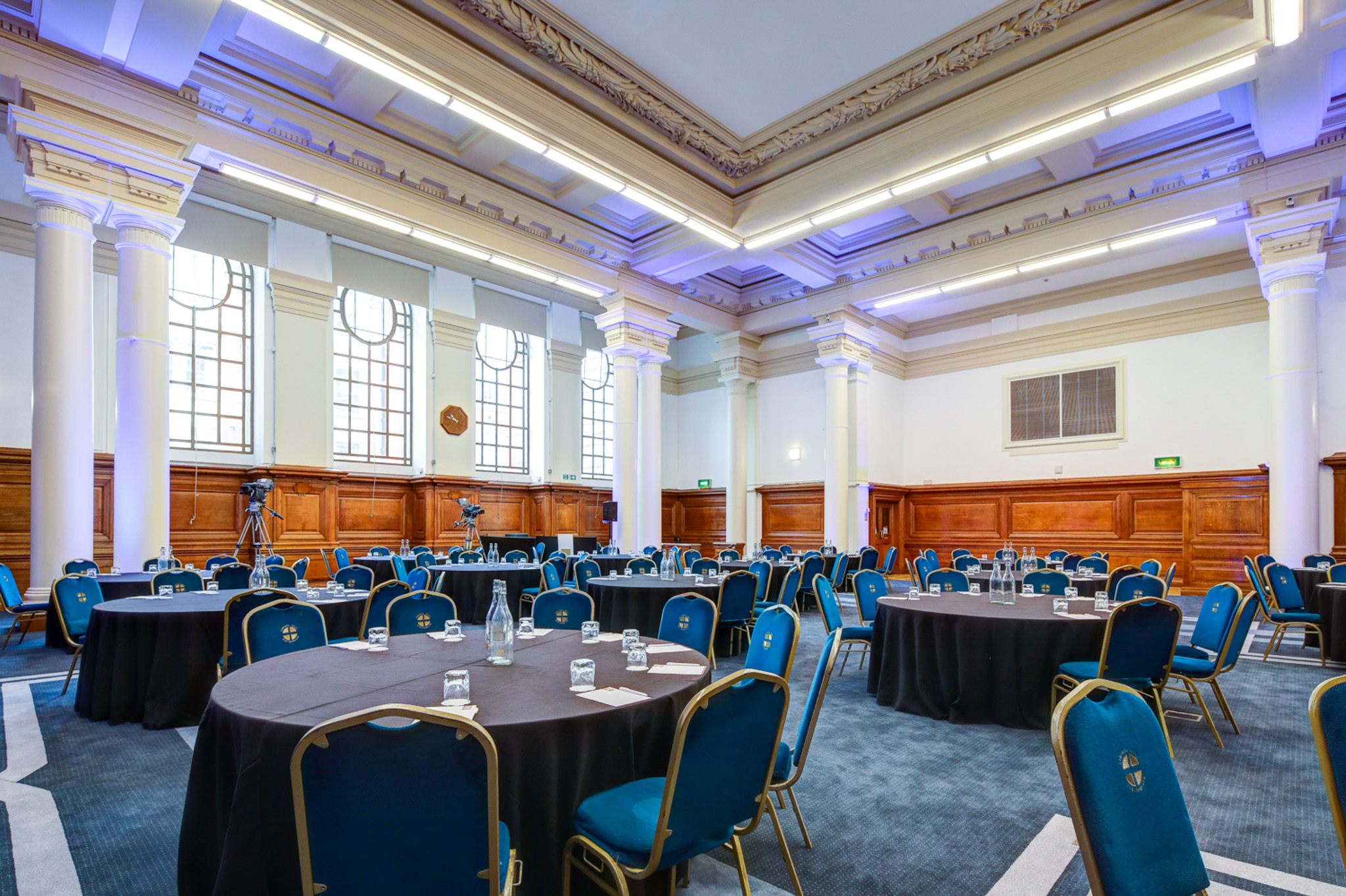 Spacious Lecture Hall with round tables, ideal for conferences and formal gatherings.