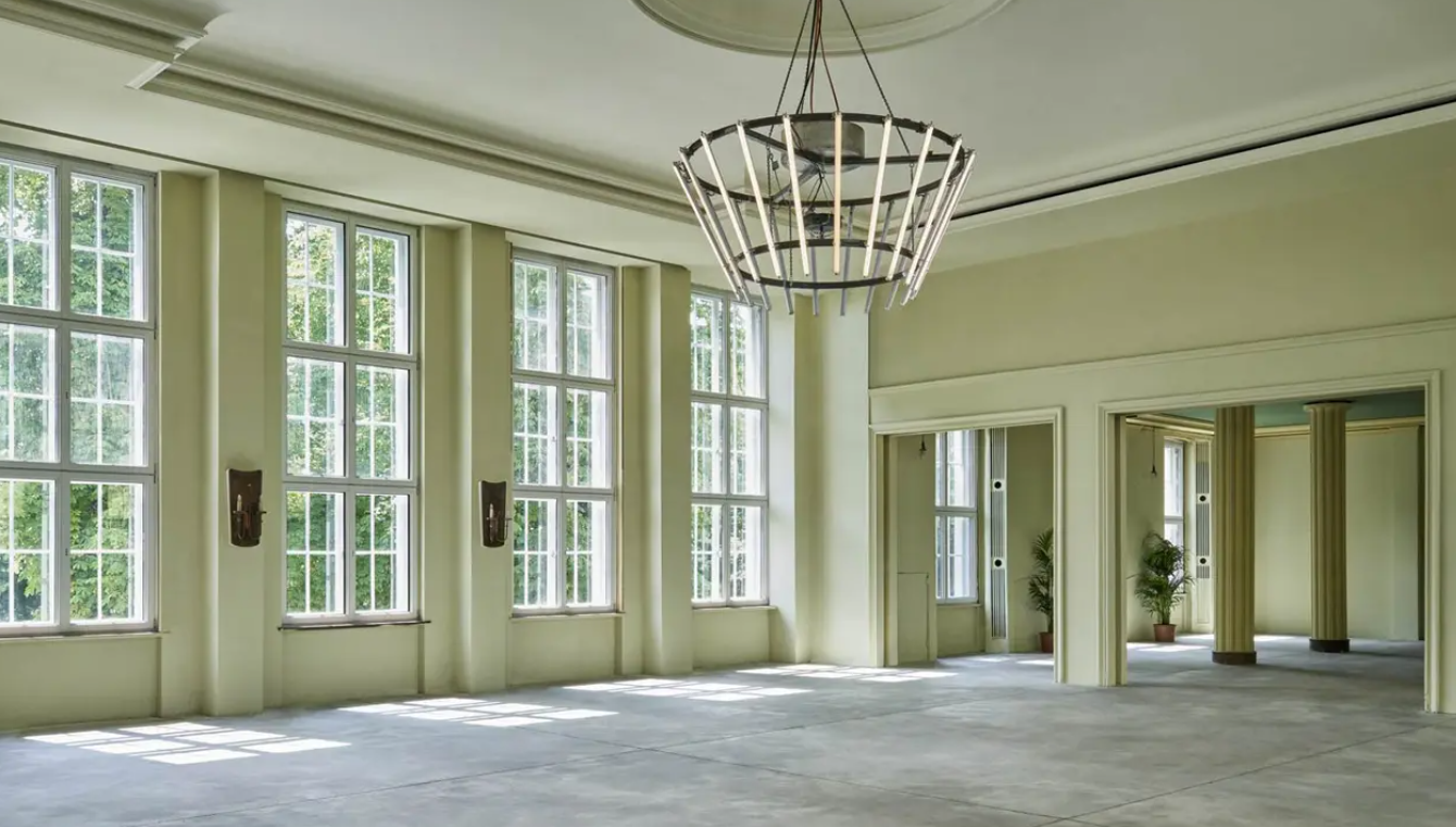 Spacious wedding venue with large windows and modern chandelier in Jarod Test.