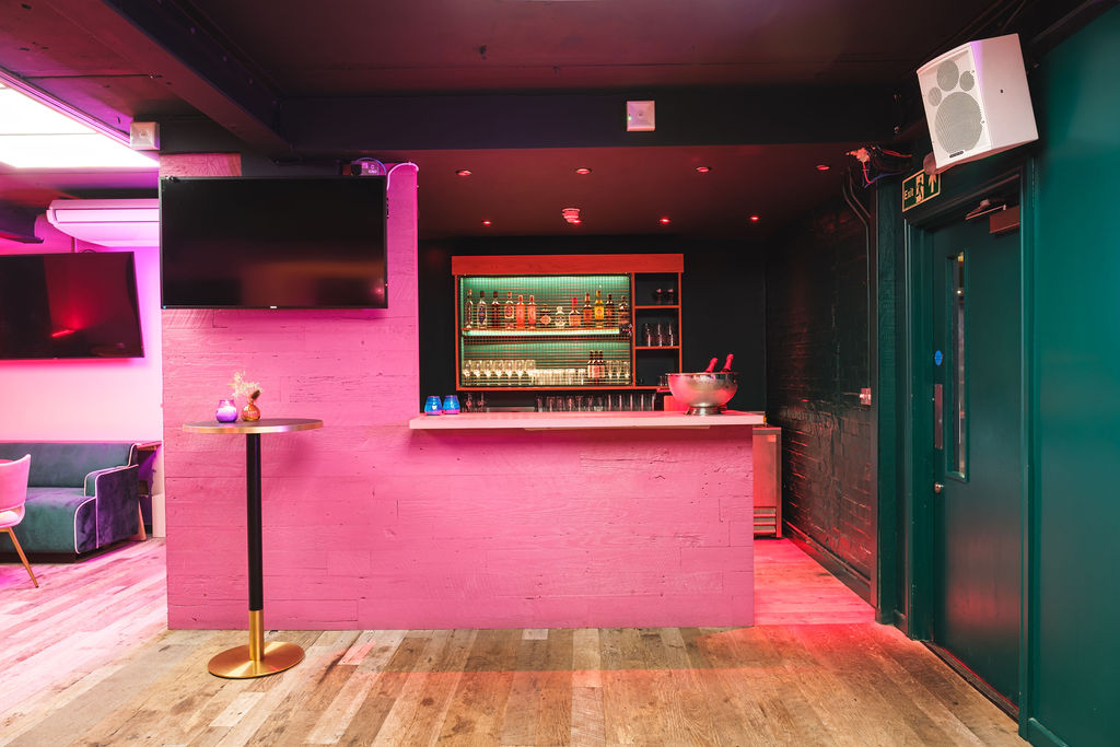 Modern bar at The Glam Palace, vibrant lighting for events and gatherings.