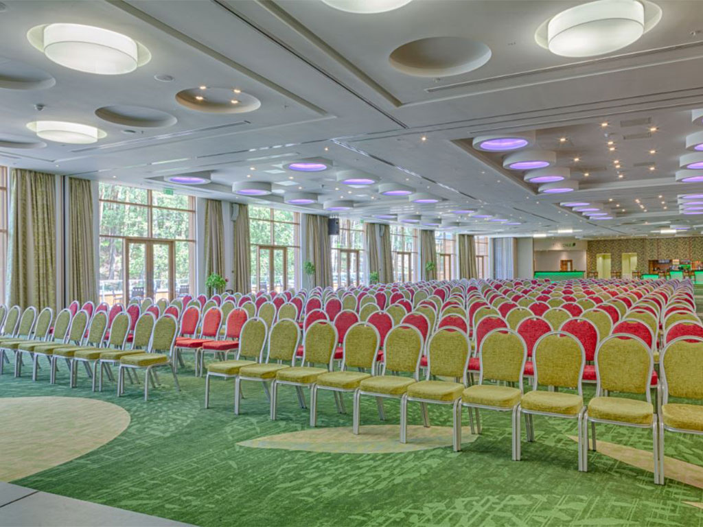 Main Meeting Room at Centre Parcs, Woburn Forrest, spacious venue for events with colorful chairs.