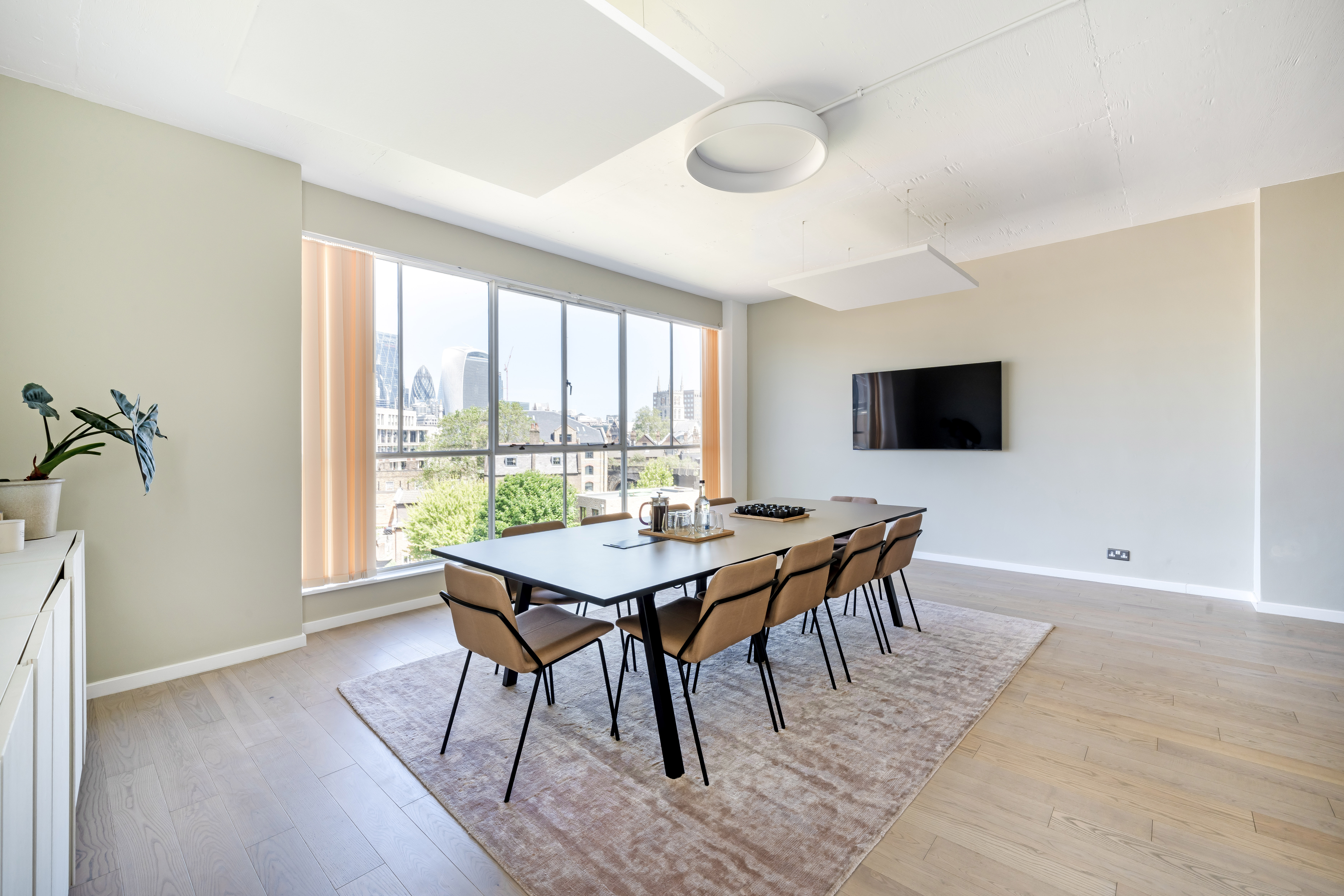 Modern Menier Meeting Room with large table, ideal for collaborative meetings and presentations.