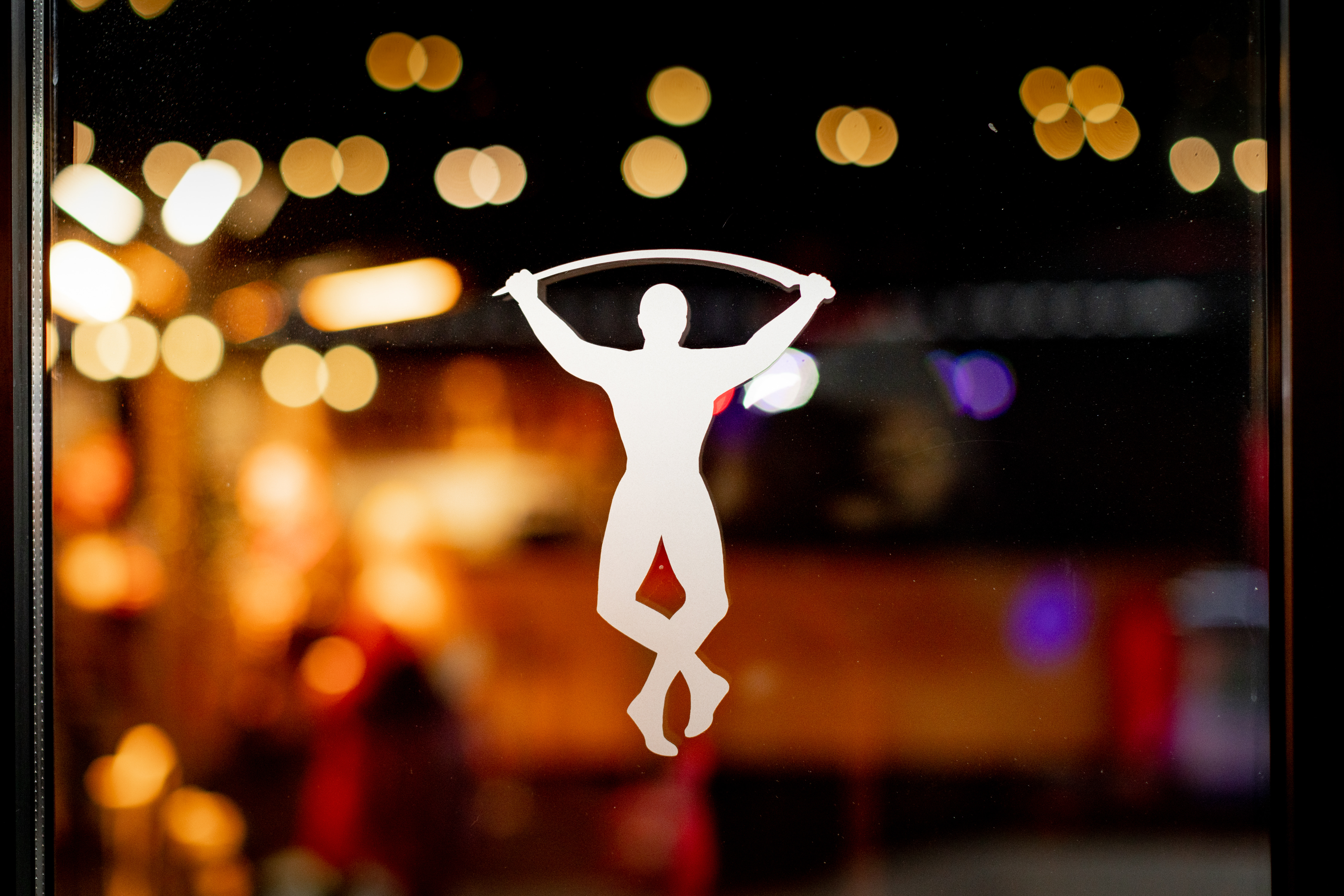 Stylized performer in warm bokeh lights at Twickenham Stoop for engaging events.