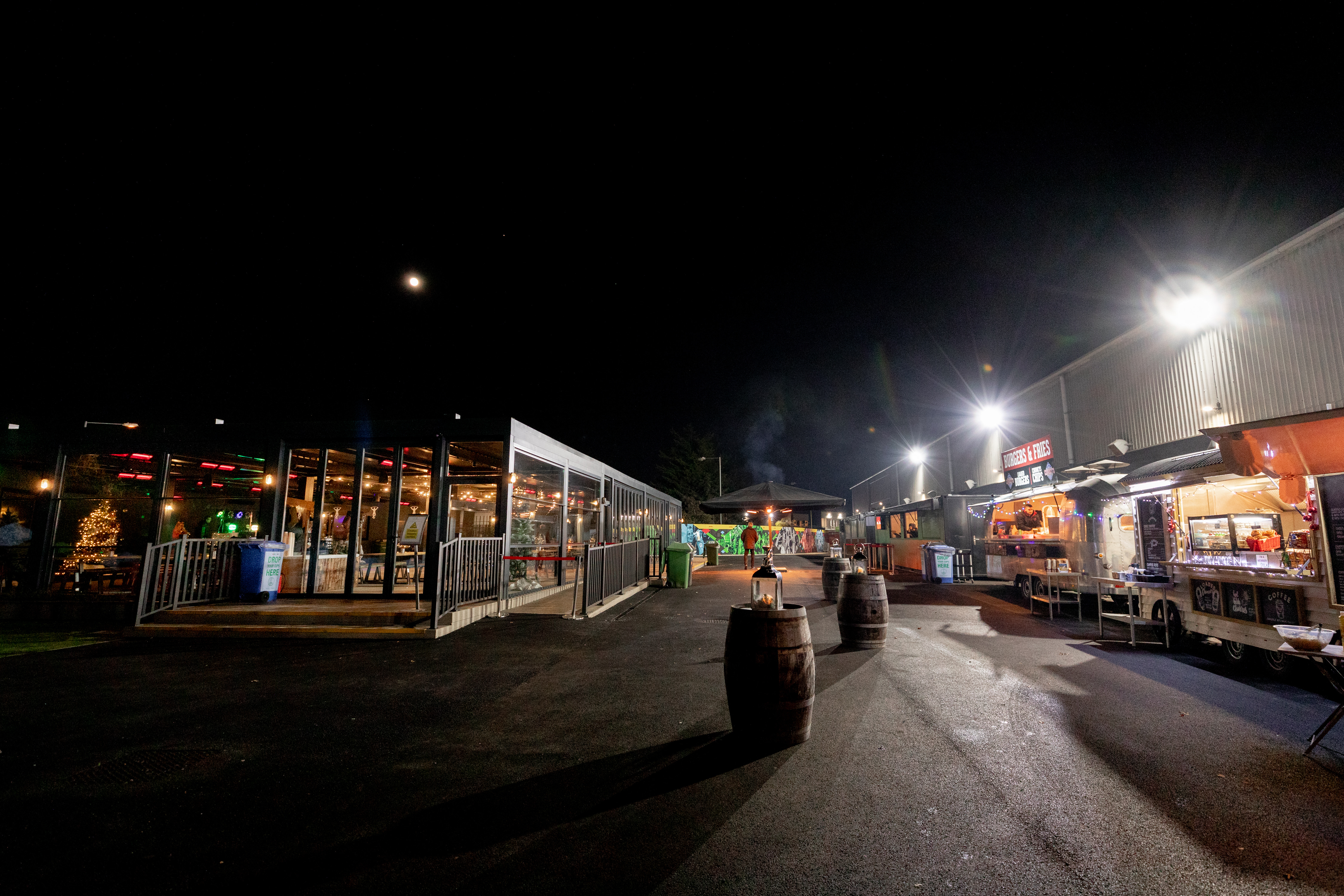 Vibrant outdoor event space at night with food stalls in Twickenham Stoop Stadium.