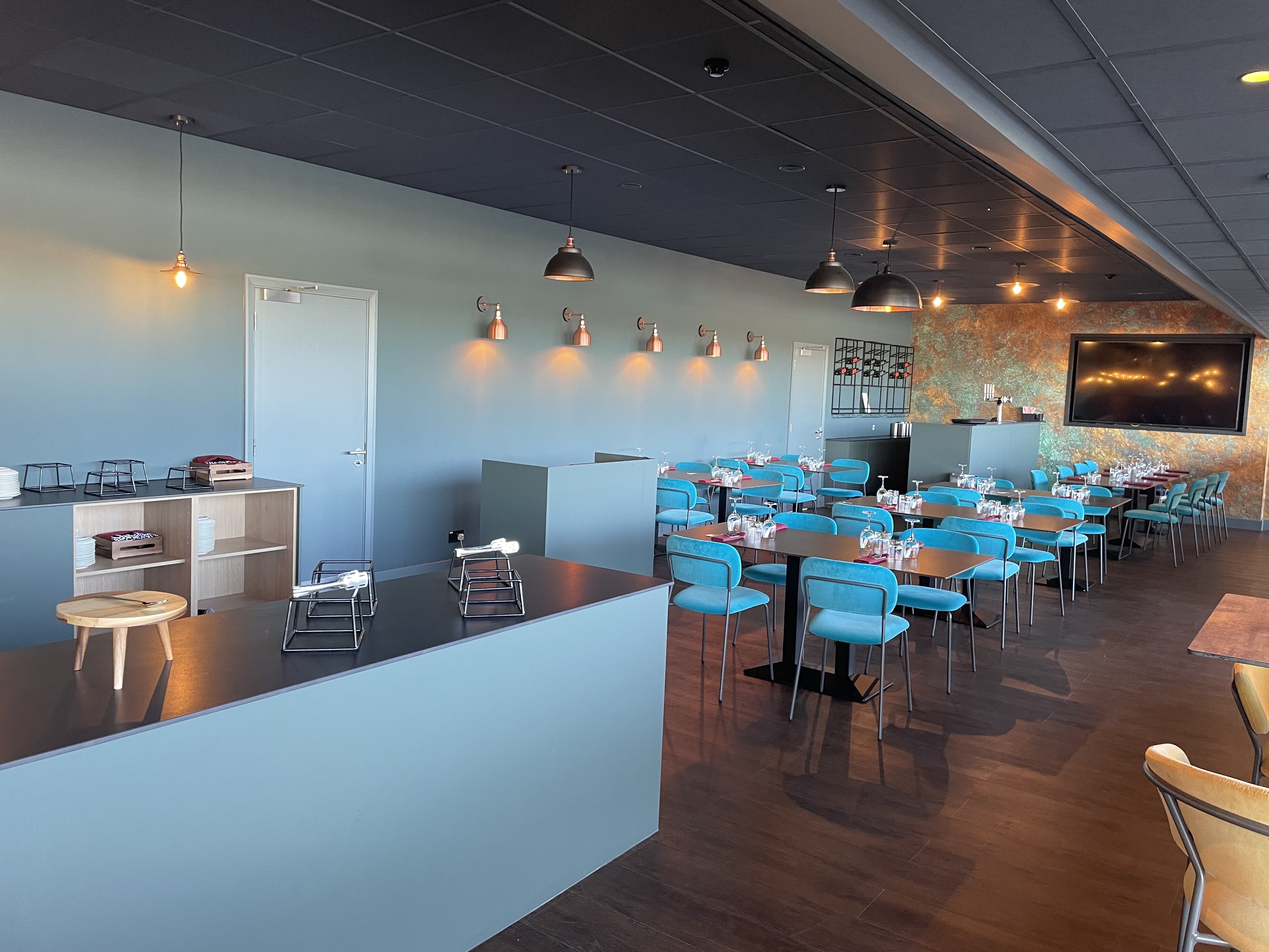 Modern event space at The Twickenham Stoop with turquoise chairs for networking events.