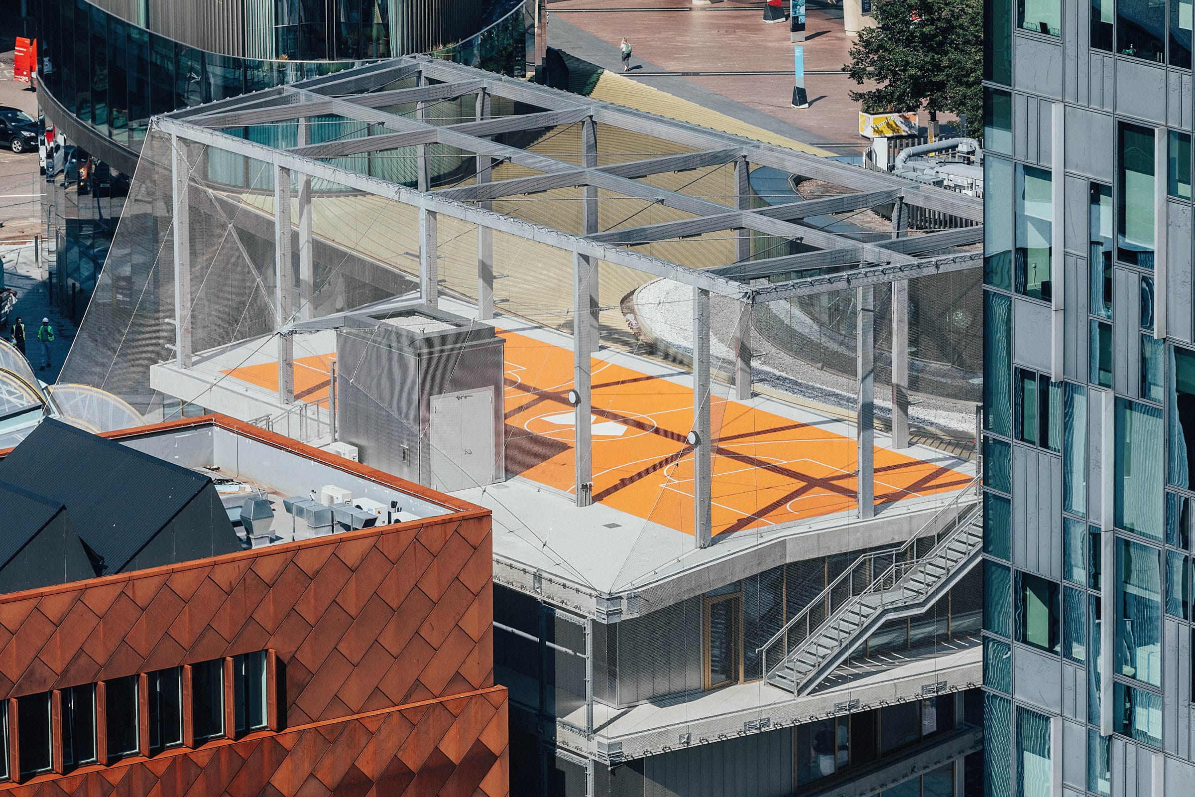 Transparent event space in Design District London with vibrant orange flooring for gatherings.