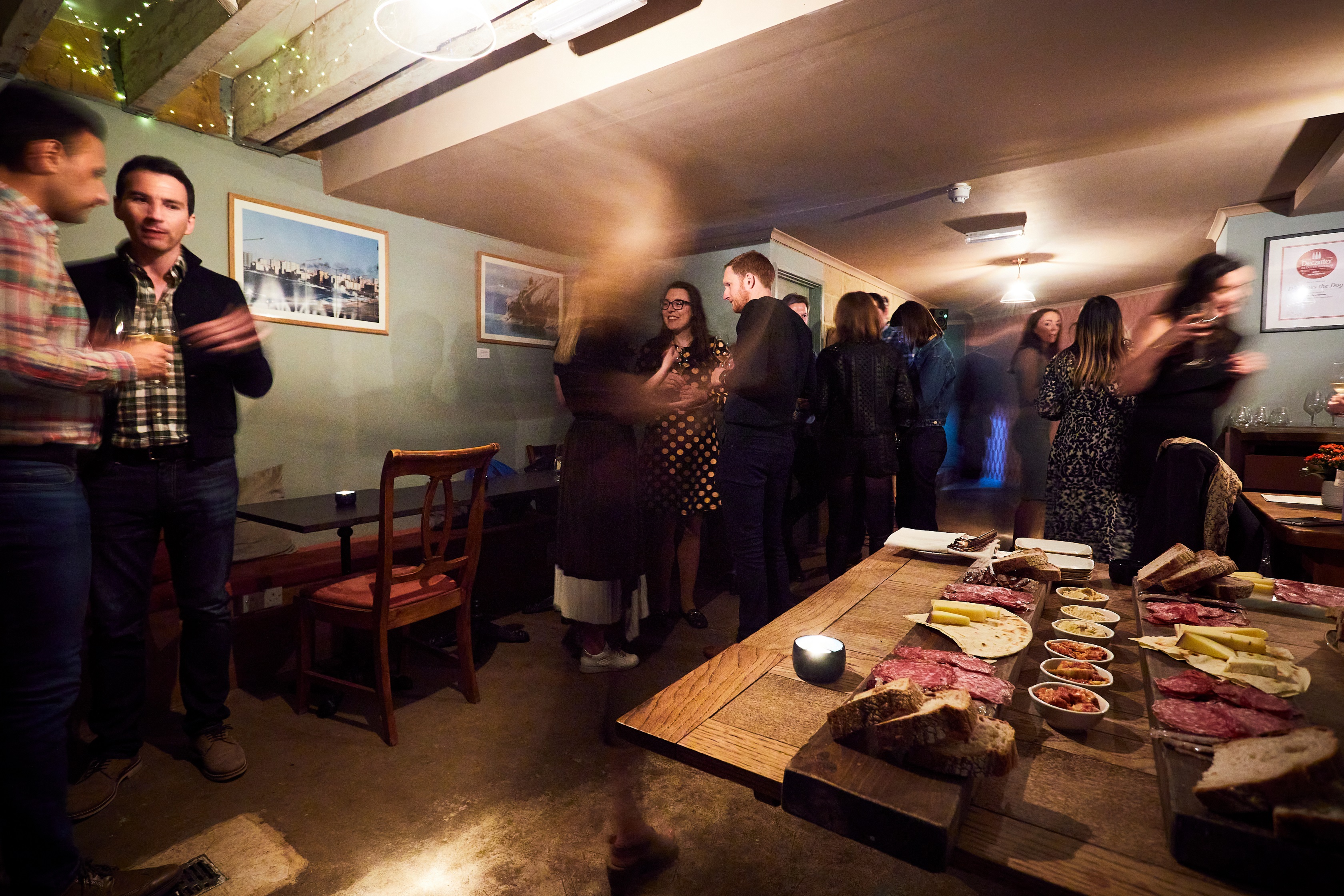 Vibrant networking event at The Cellar with cozy ambiance and charcuterie spread.