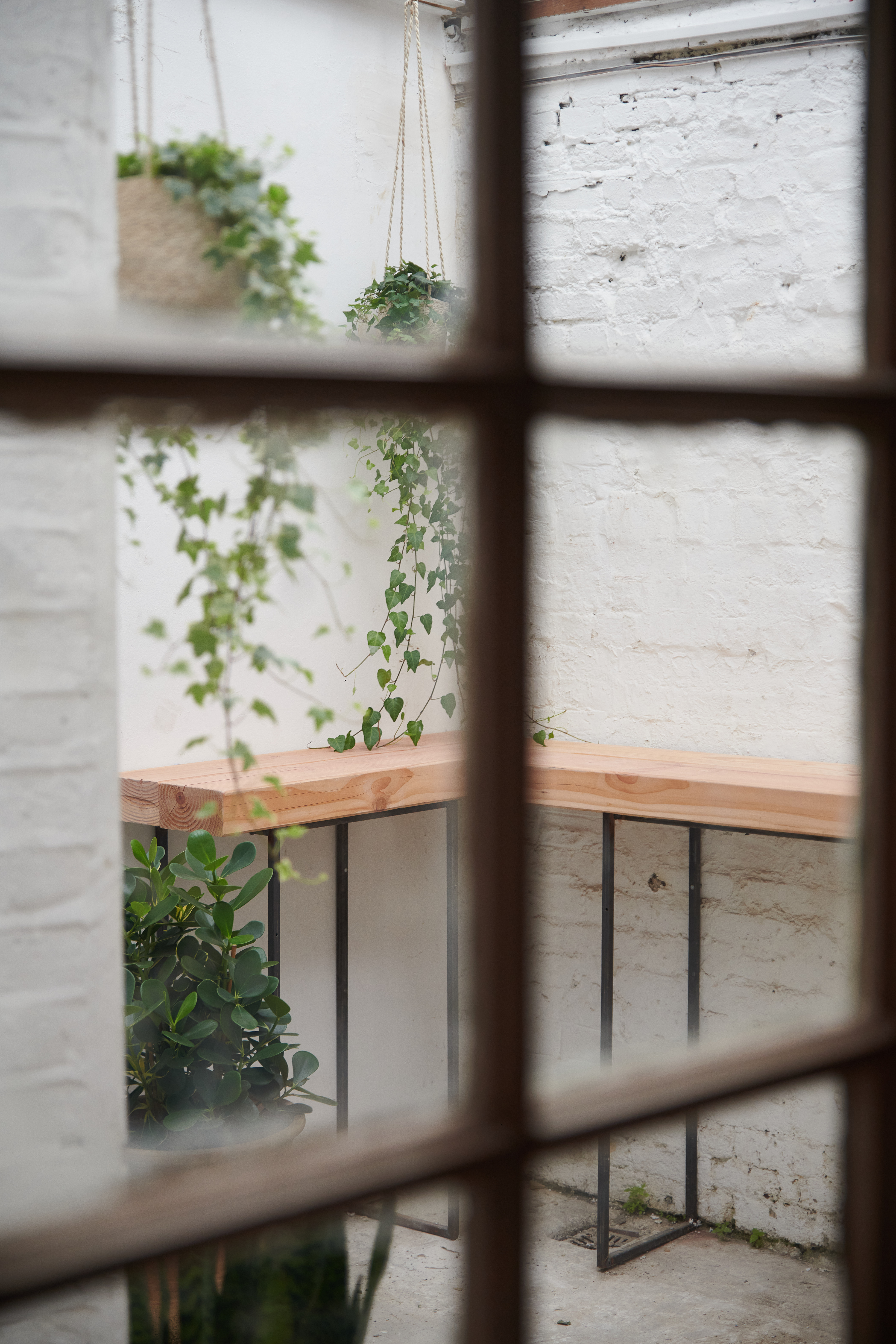 Serene meeting space with wooden table and greenery, perfect for creative workshops.