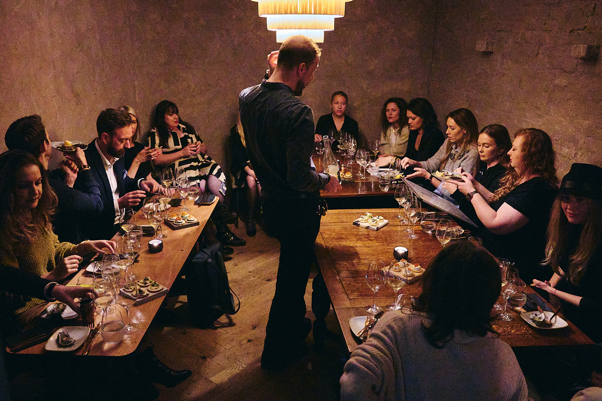 Intimate dinner event with guests at a wooden table, perfect for networking and celebrations.