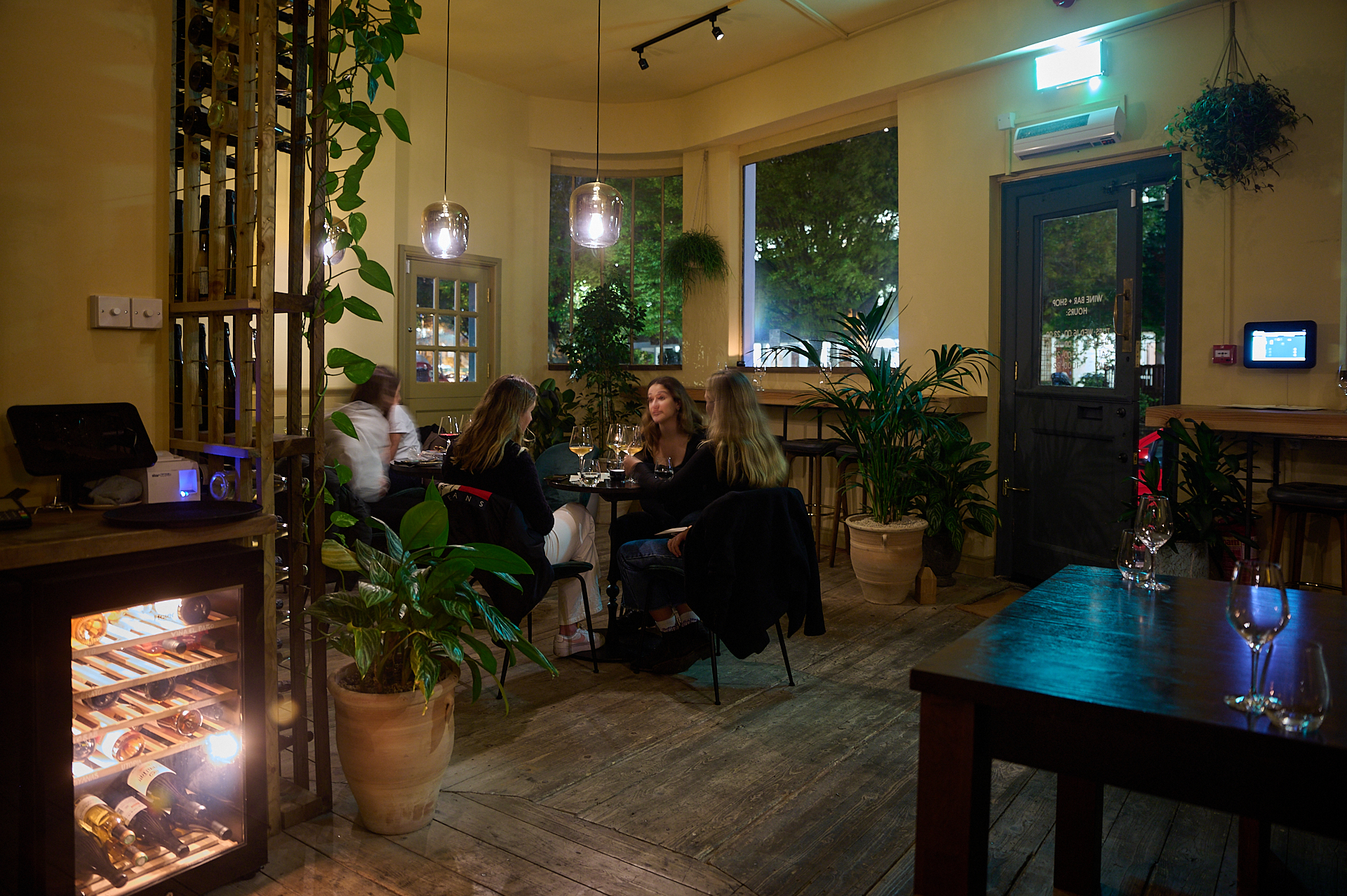 Cozy dining space for private events with warm lighting and wine fridge.