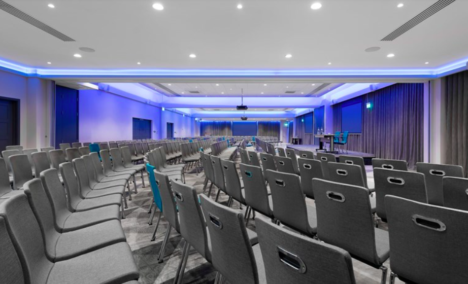 Modern conference space at The Rosewood - Woodlands with gray chairs and AV equipment.