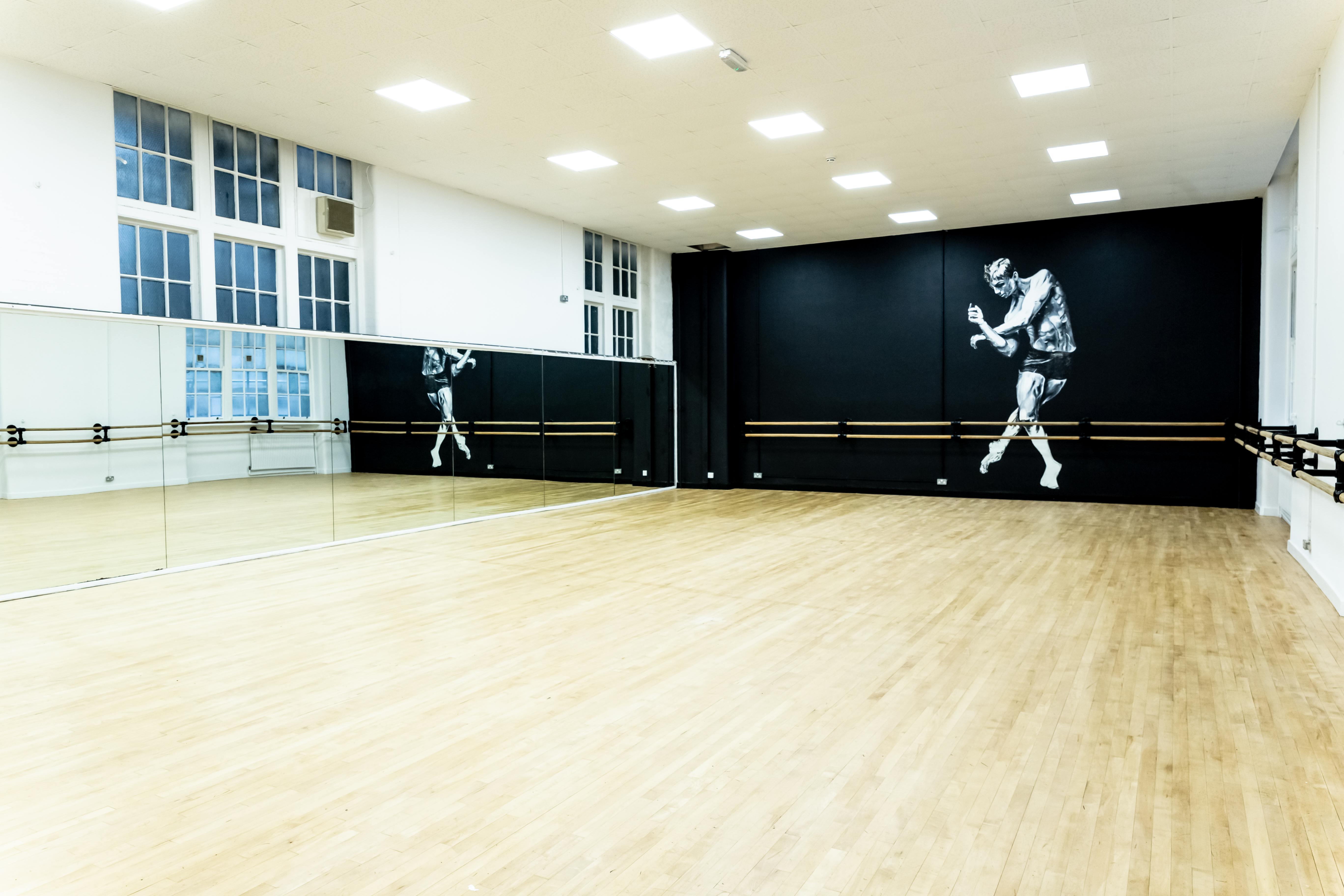 Spacious dance studio with mirrors and natural light at City Academy, ideal for workshops.