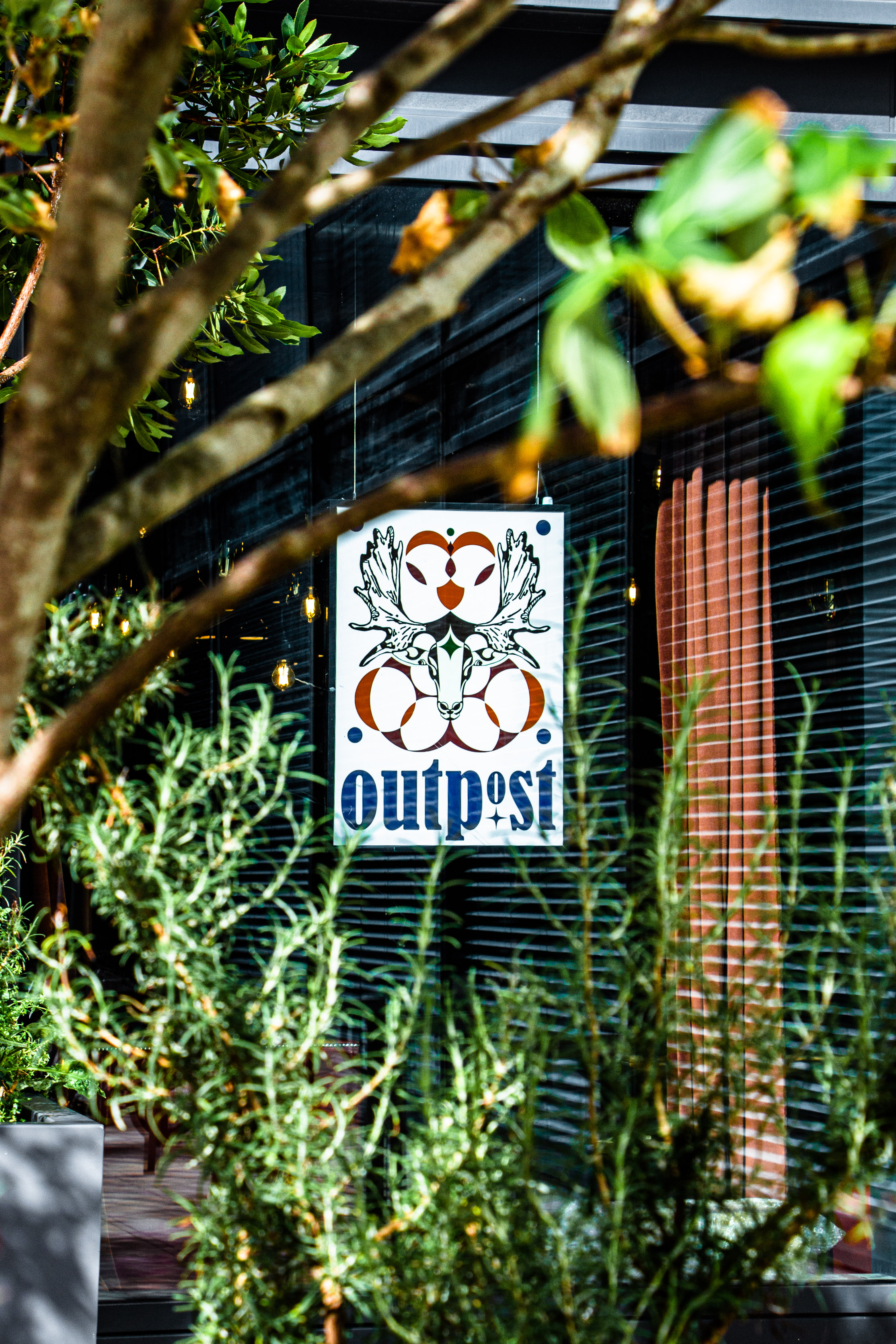 Stylish Outpost venue sign with greenery, perfect for meetings and events.