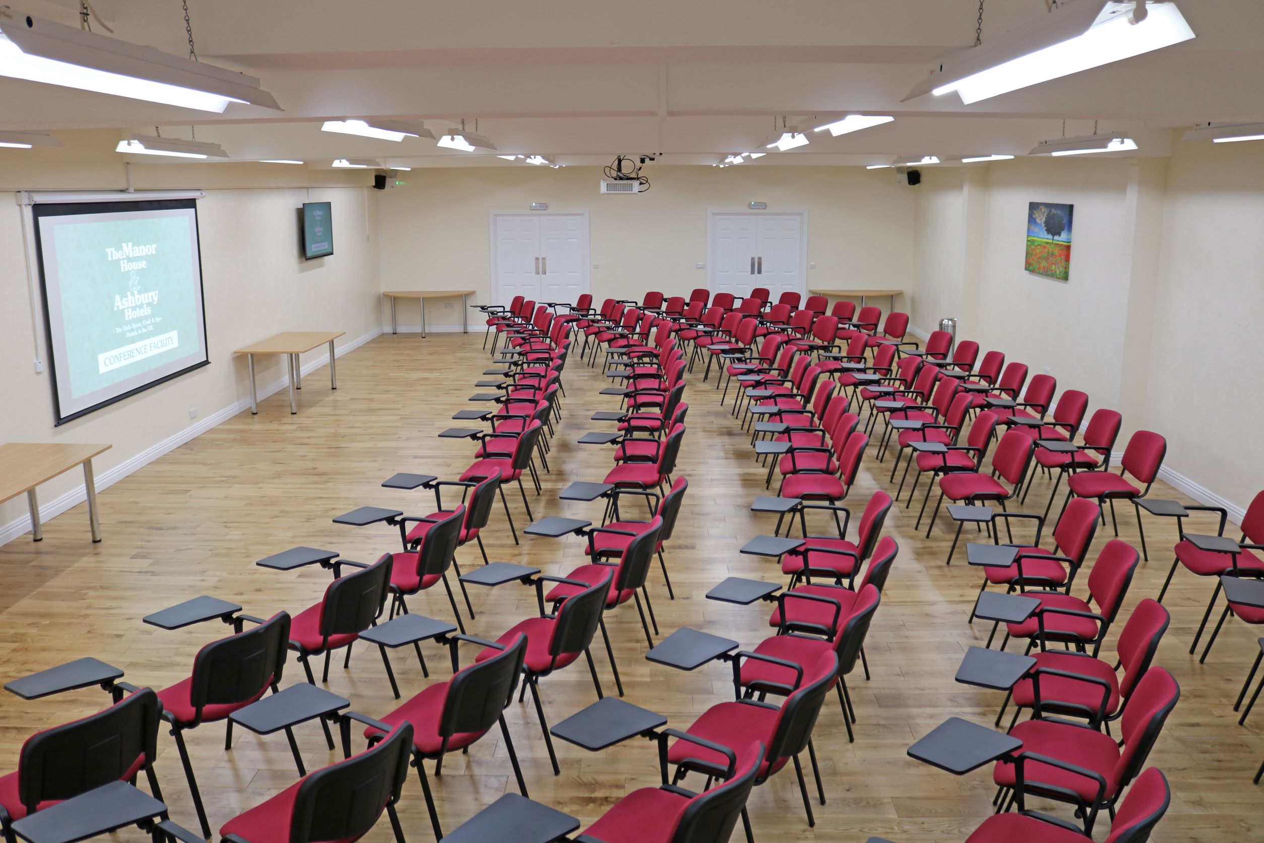 Theater-style meeting space with red chairs, perfect for workshops and seminars.