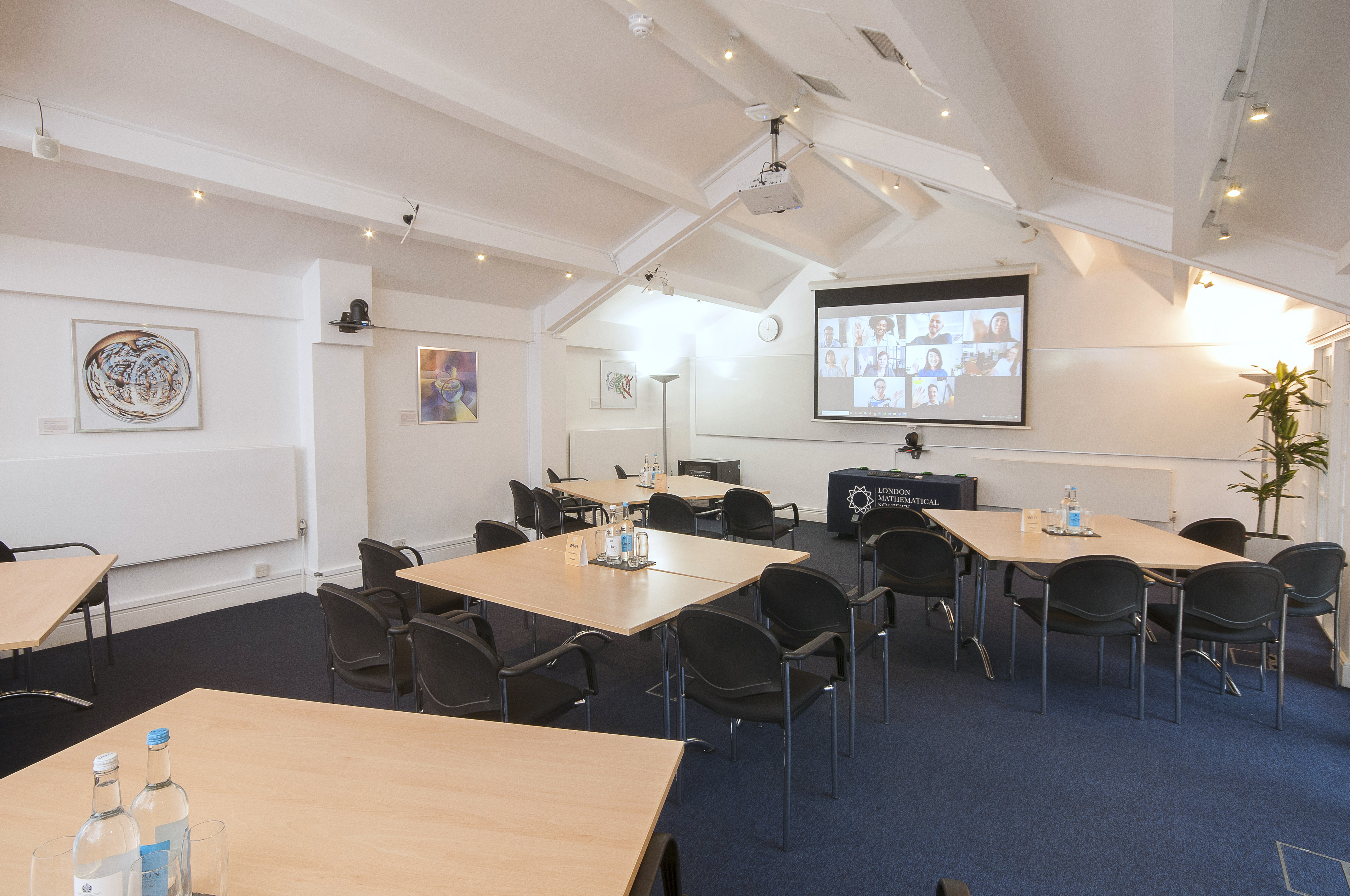 Hardy Room in De Morgan House, modern hybrid meeting space with large screen.