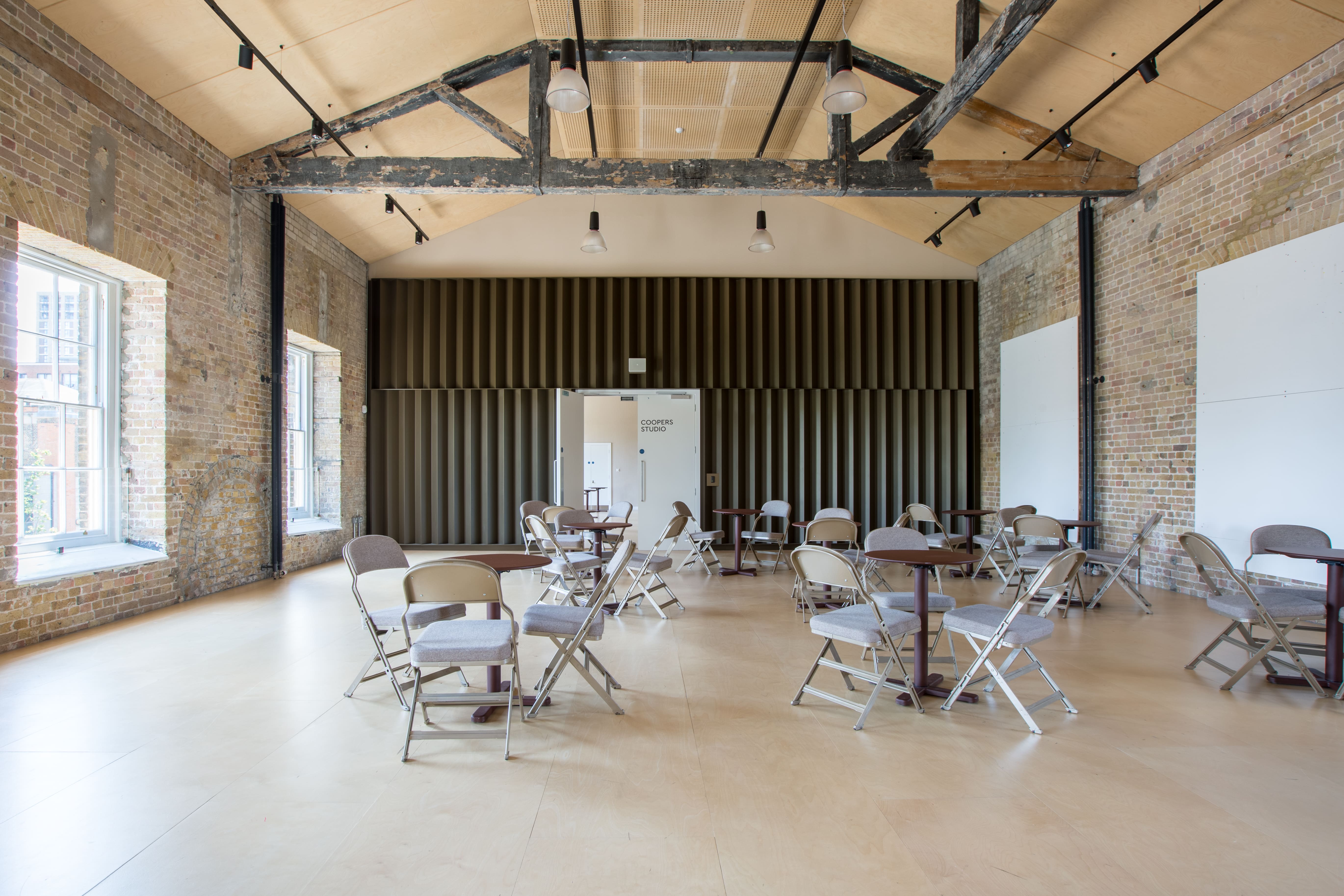 Coopers Studio event space with exposed brick walls, ideal for meetings and gatherings.
