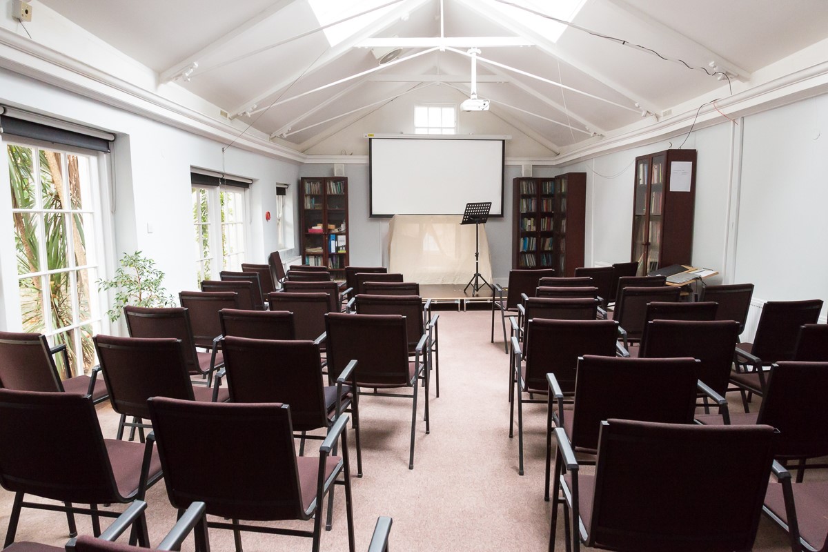 Guild Hall meeting space with projector screen, ideal for workshops and training sessions.