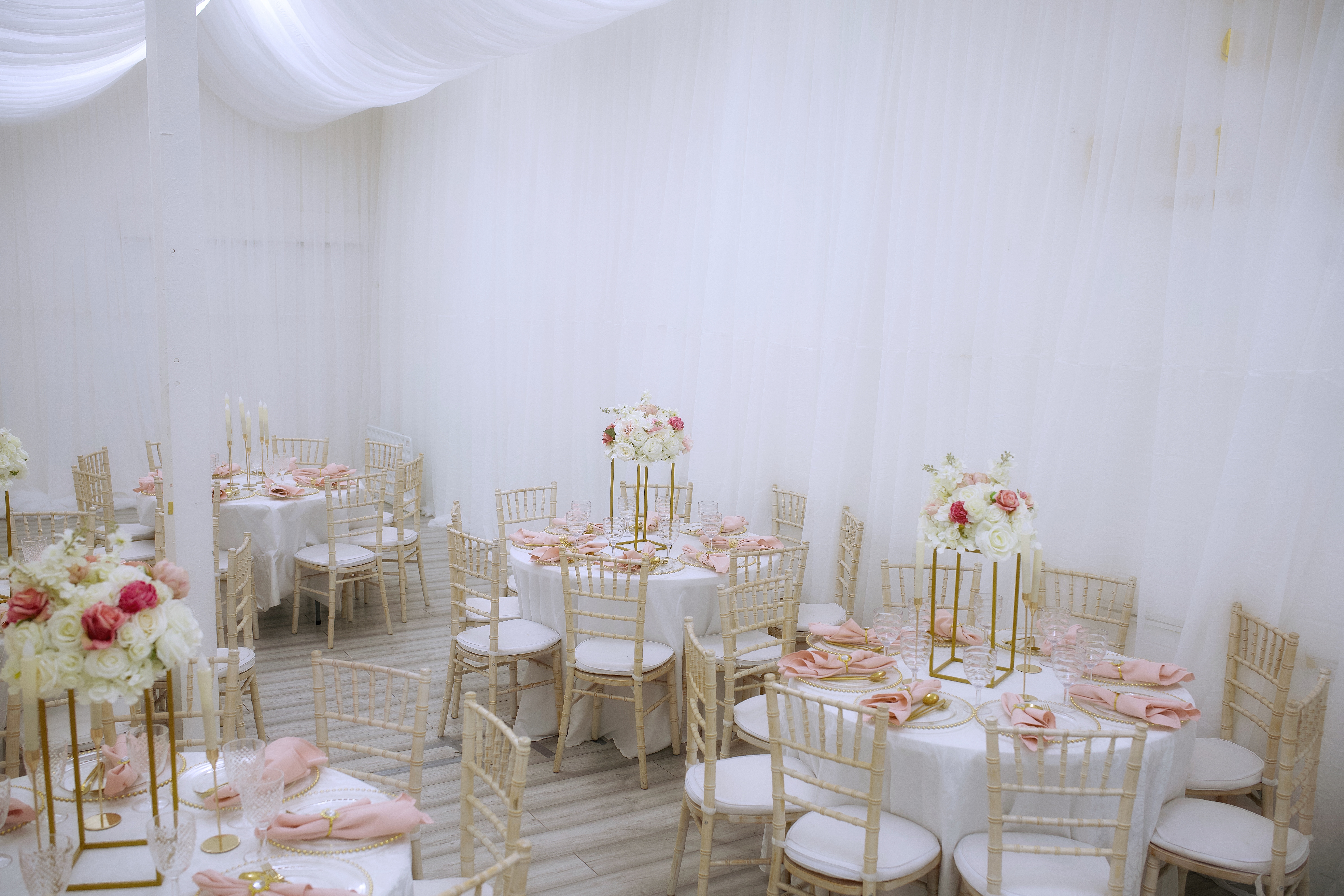 Elegant wedding venue with pink linens and floral centerpieces, ideal for upscale events.