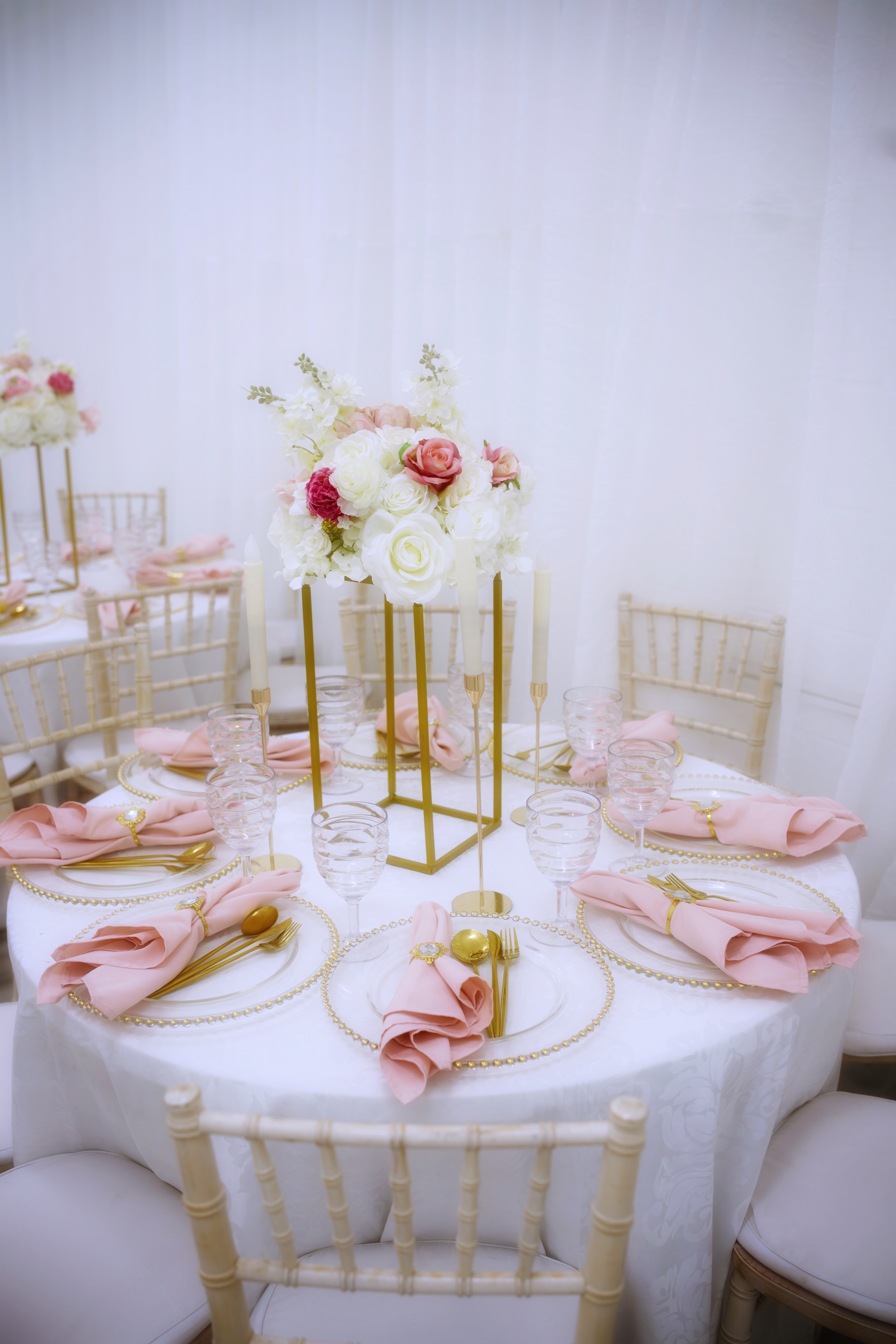 Elegant table setting with pink floral centerpiece for weddings and upscale events.