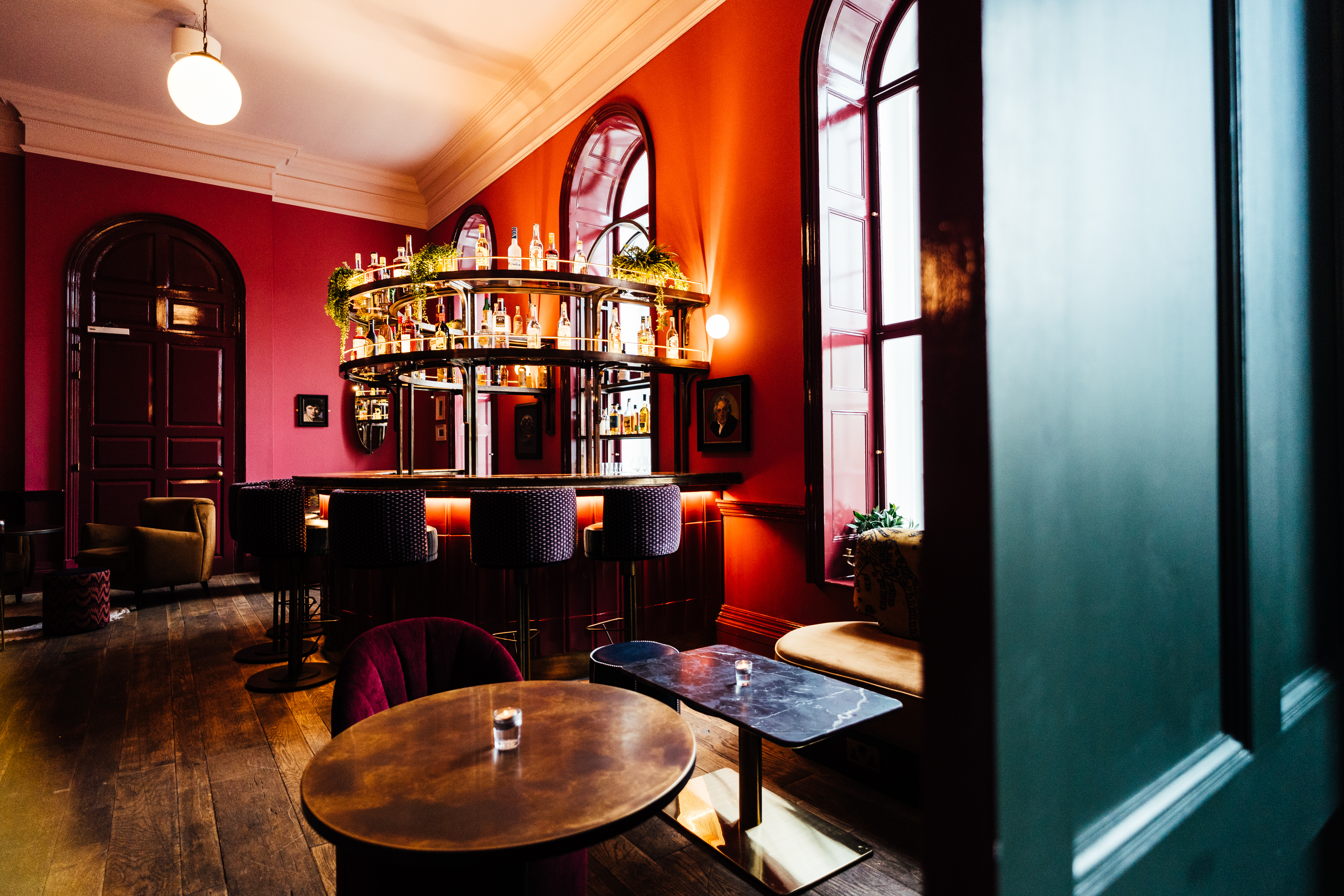 Stylish lounge with circular bar, vibrant red walls for networking events in Kindred.