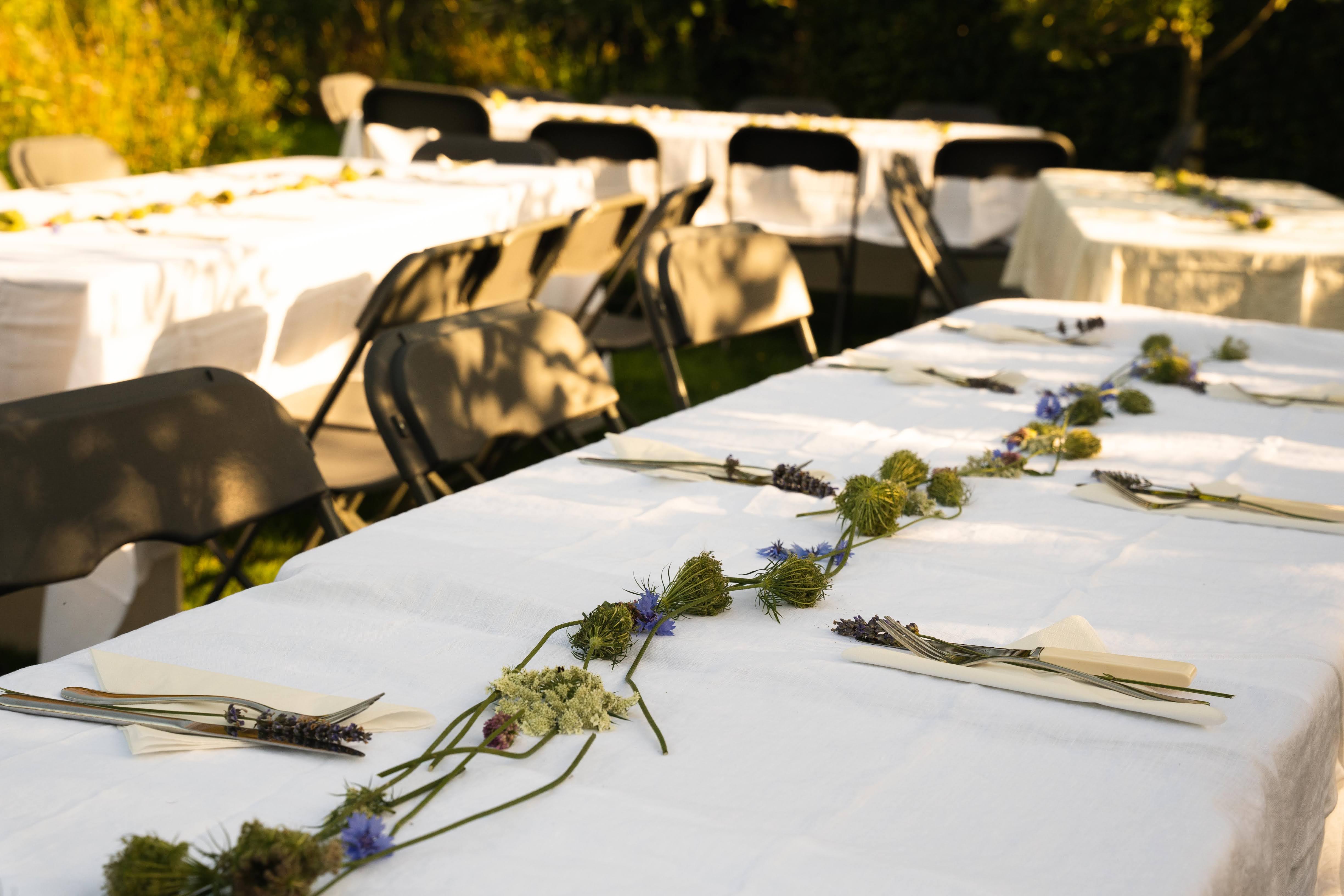 Elegant outdoor dining at Omved Gardens with floral centerpiece for events.