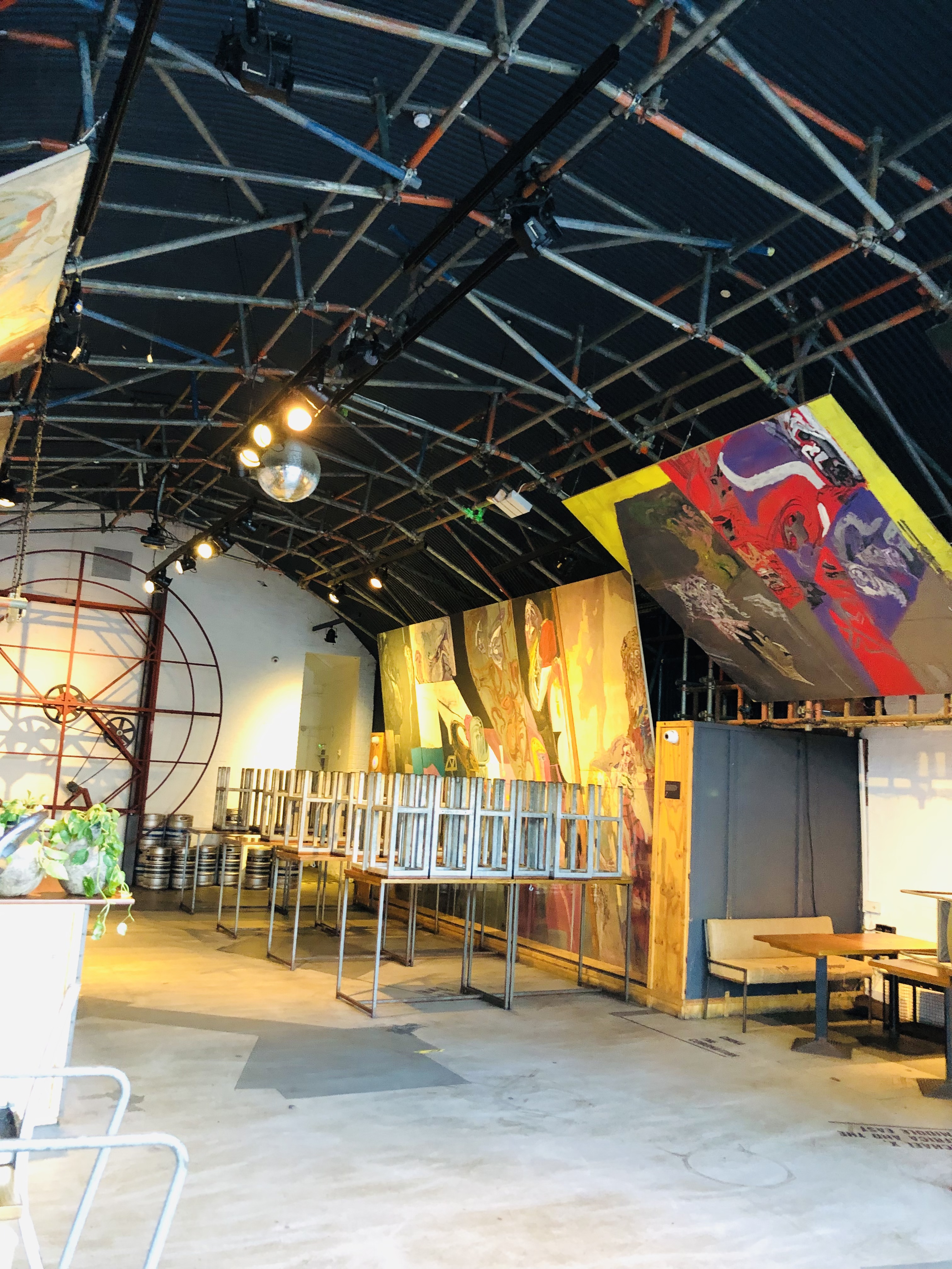 "Arch 1 in Topolski: industrial event space with exposed beams and vibrant artwork."