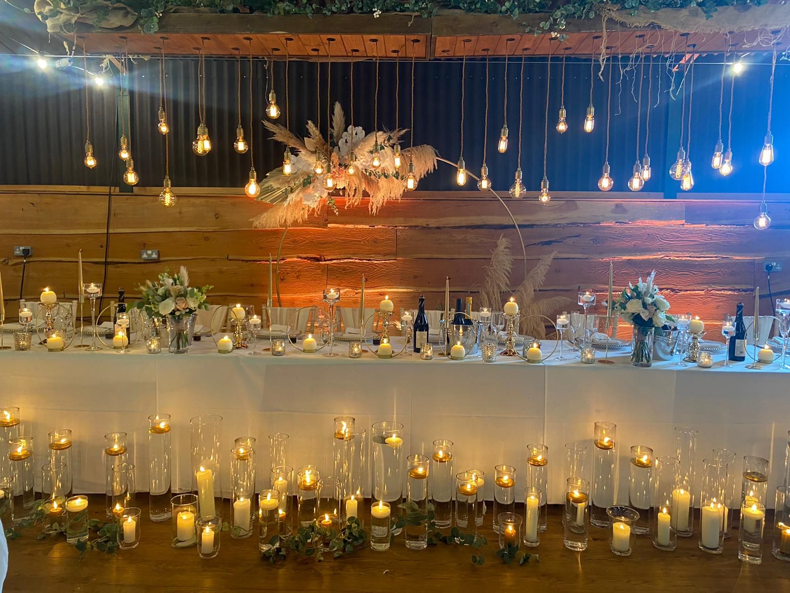 Elegant long table with candles in Stock Farm Barn for weddings and upscale events.