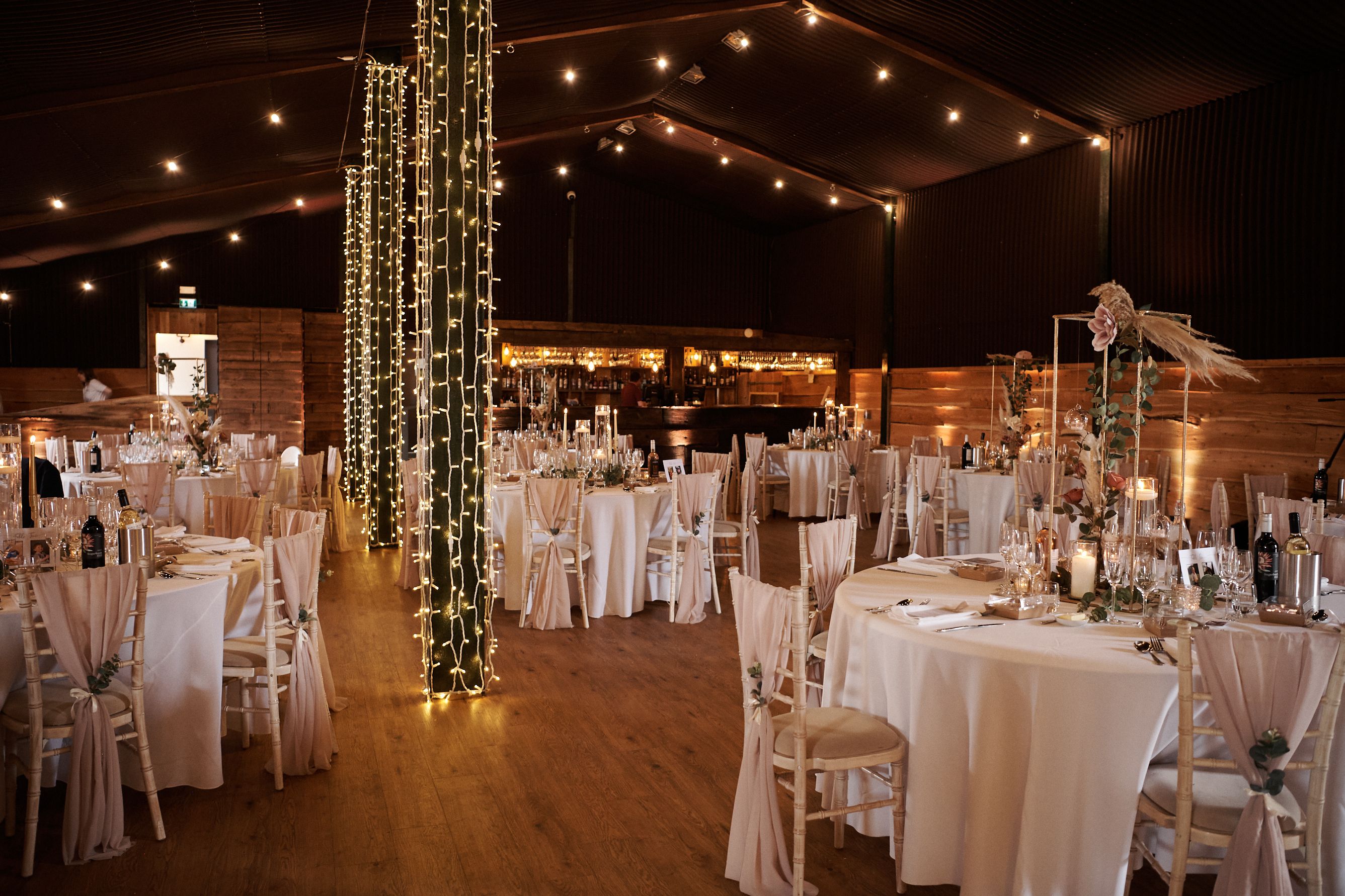 Stock Farm Barn wedding venue with elegant tables and warm string lights ambiance.