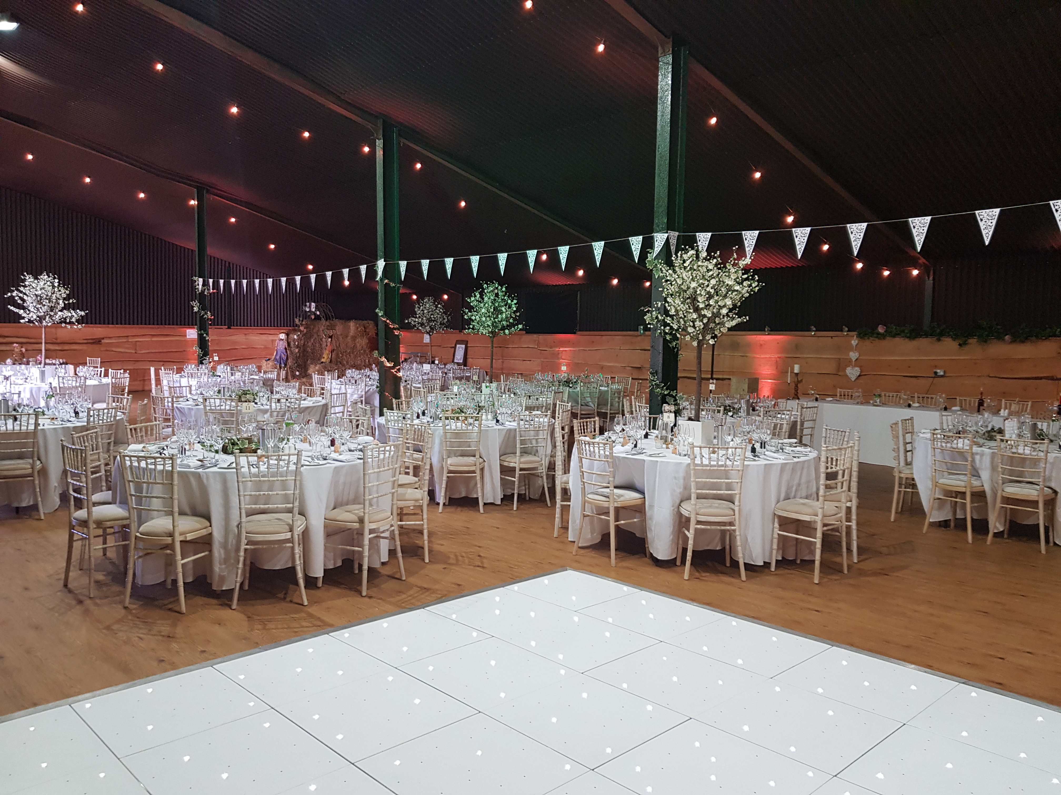 Stock Farm Barn wedding venue with elegant round tables and charming bunting decor.