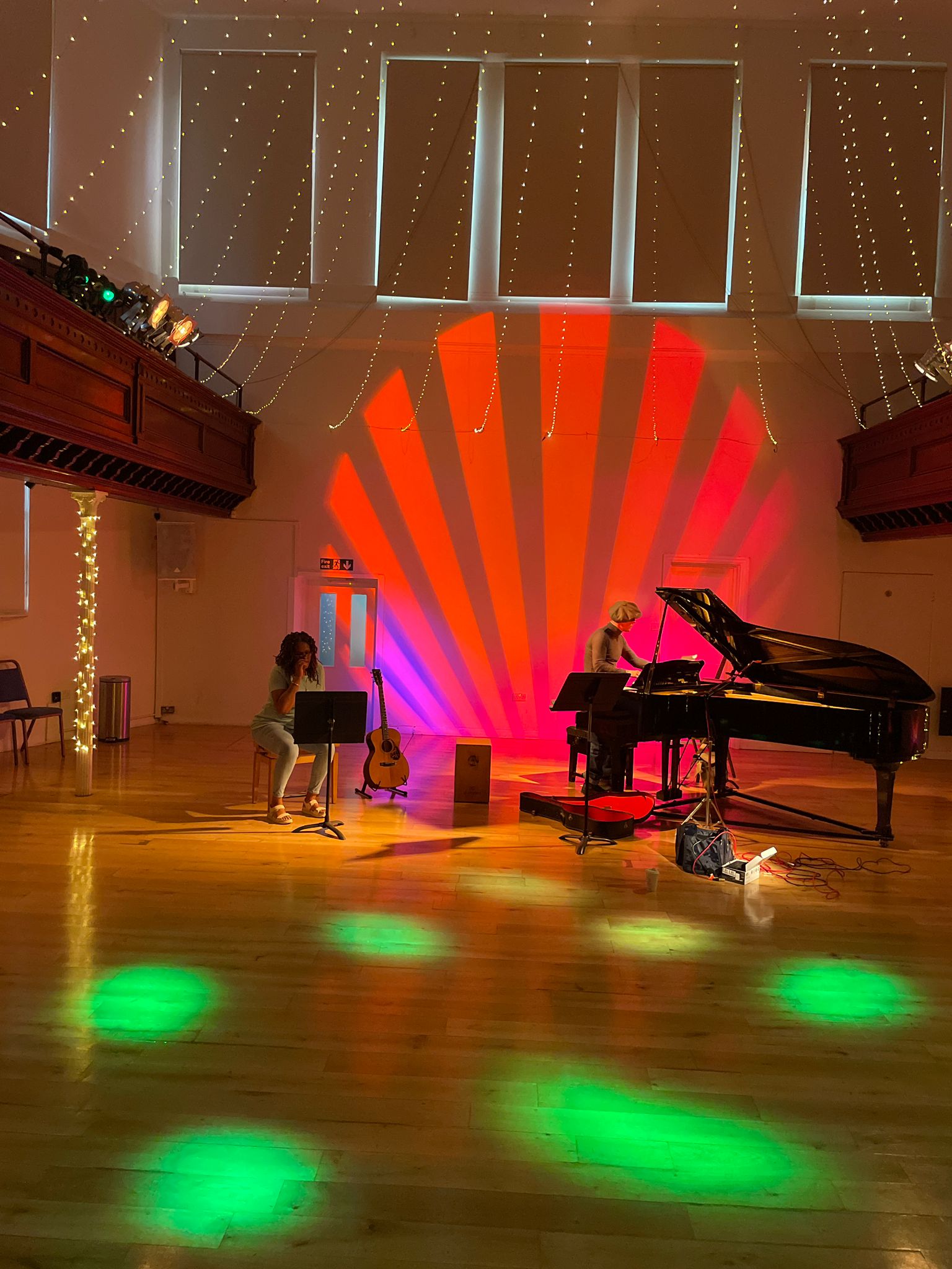 Vibrant Upper Hall event space with colorful lighting for live performances and arts gatherings.